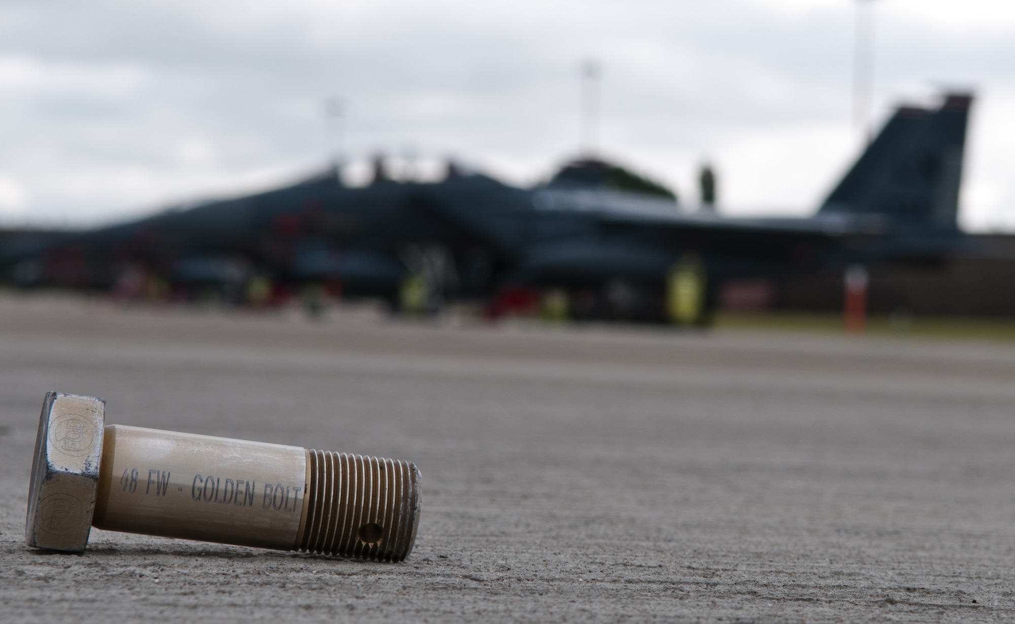 ROYAL AIR FORCE LAKENHEATH, England -- The 48th Fighter Wing Golden Bolt sits on the flightline as a piece of Foreign Object Debris Aug. 30, 2012.  Each month the golden bolt is placed somewhere on the flightline. If anyone finds the bolt and picks it up, they receive a day pass amongst other prizes from the 48th FW FOD Prevention Incentive Program.  (U.S. Air Force photo by Senior Airman Connor Estes)