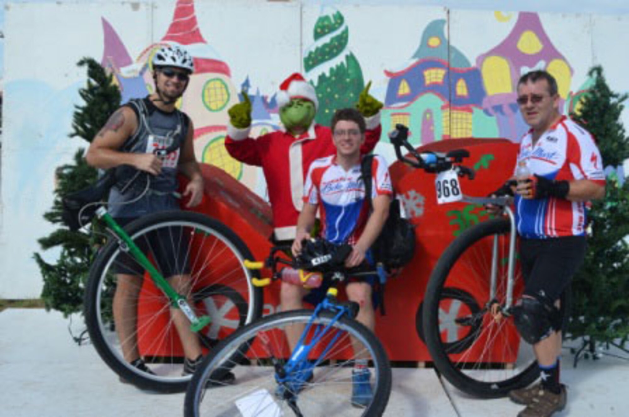 Maj. Oliver Ulmer, 363rd Training Squadron commander, dressed as the "Grinch", poses with cyclists during the 31st annual Hotter N' Hell bike race Aug. 25, 2012.  This is the fifth straight year a unit from Sheppard has sponsored an off-base pit stop. (U.S. Air Force courtesy photo)