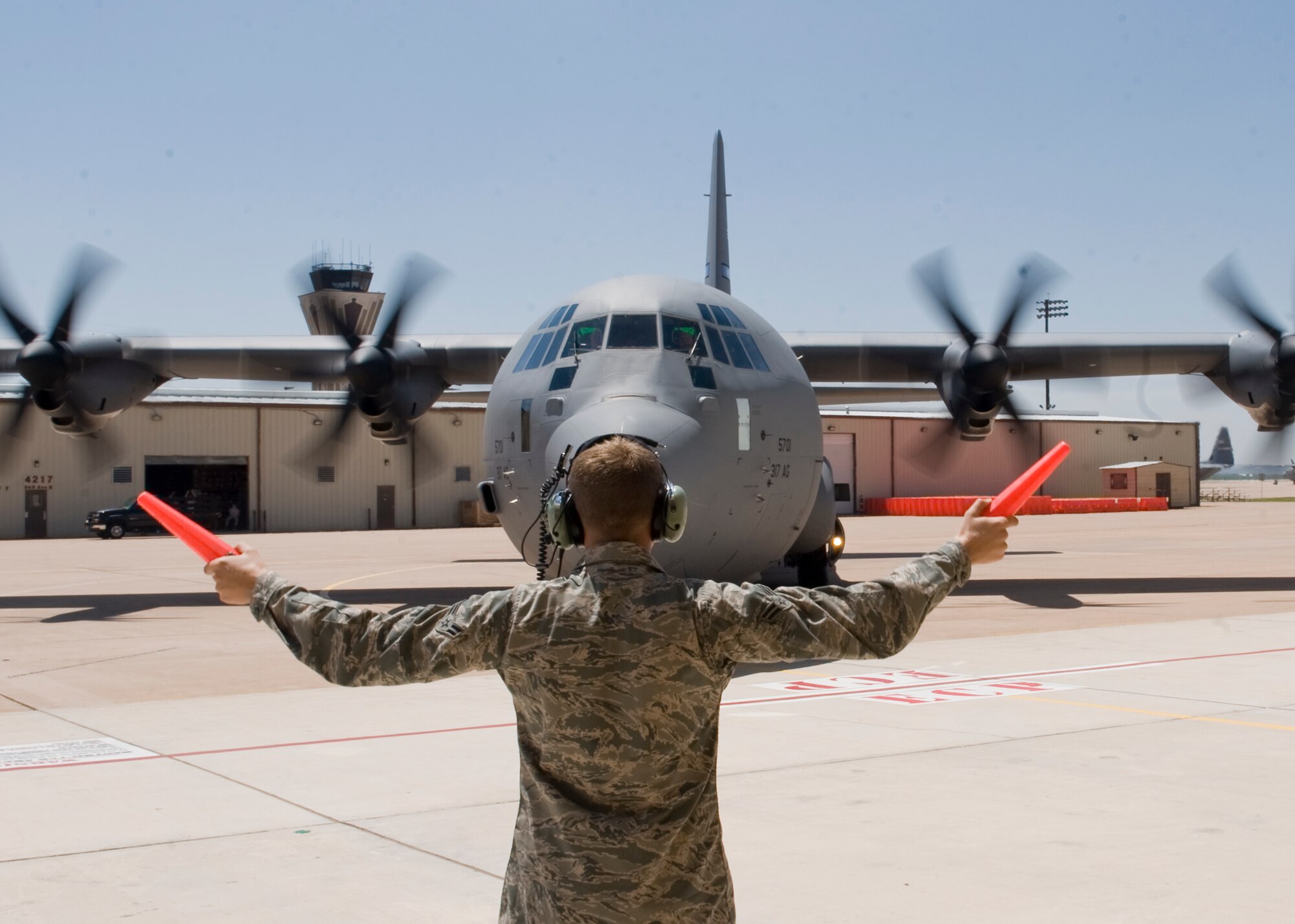 U.S. Air Force Airman 1st Class David Howard, 317th Aircraft Maintenance Squadron, marshals the newest C-130J Super Hercules Aug. 29, 2012, at Dyess Air Force Base, Texas. The aircraft, delivered personally by U.S. Air Force Gen. William Fraser III, U.S. Transportation Command commander, is the 22nd of 28 to be delivered to Dyess by 2013, replacing the current legacy fleet of C-130 H-models. (U.S. Air Force photo by Airmen 1st Class Peter Thompson/ Released)