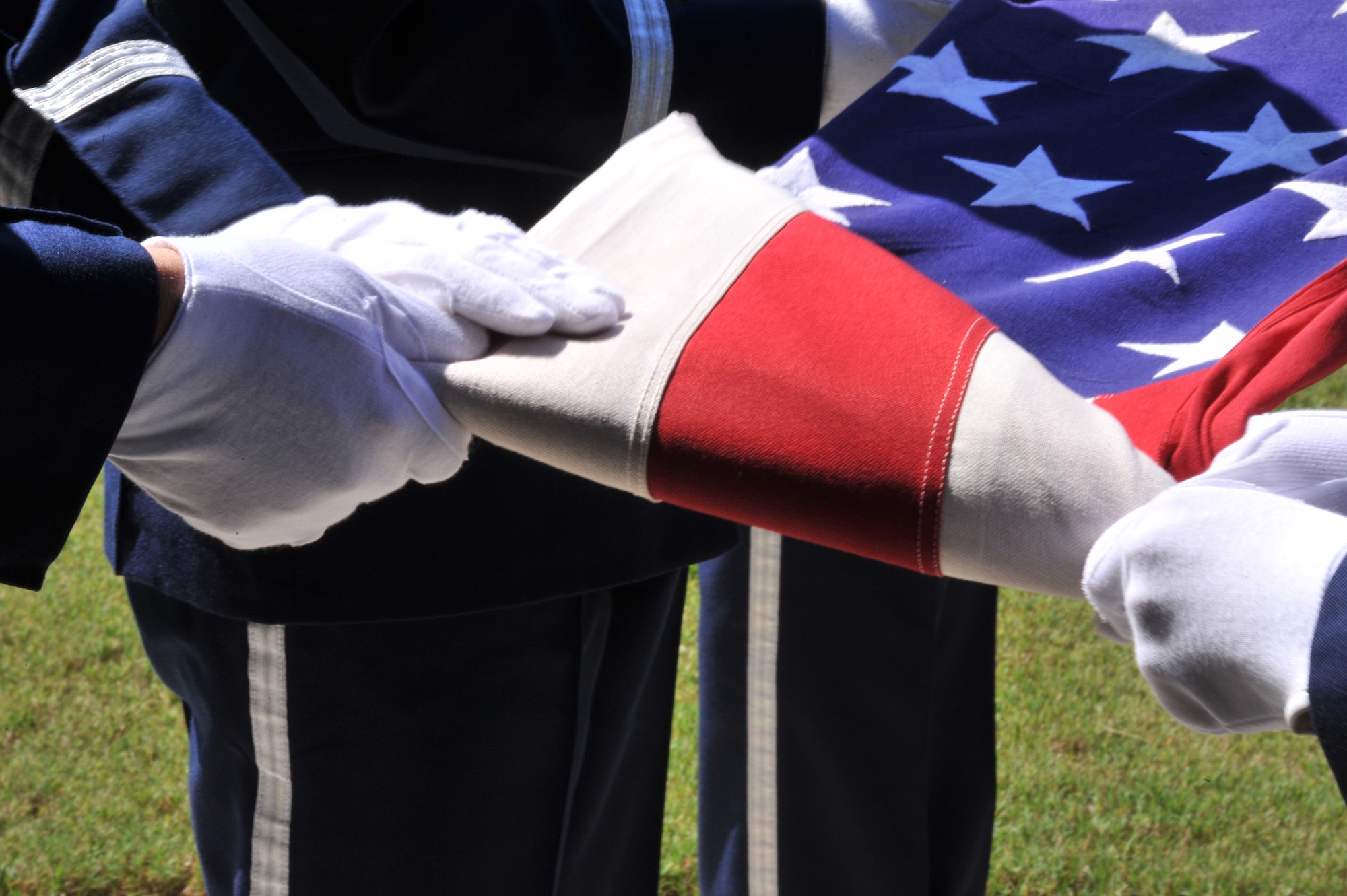 Airmen from Maxwell Air Force Base Honor Guard fold the American flag during a funeral at Alabama National Cemetery, August 22. The flag is presented to the next of kin to the deceased during the ceremony. (U.S. Air Force photo by Airman 1st Class William Blankenship)