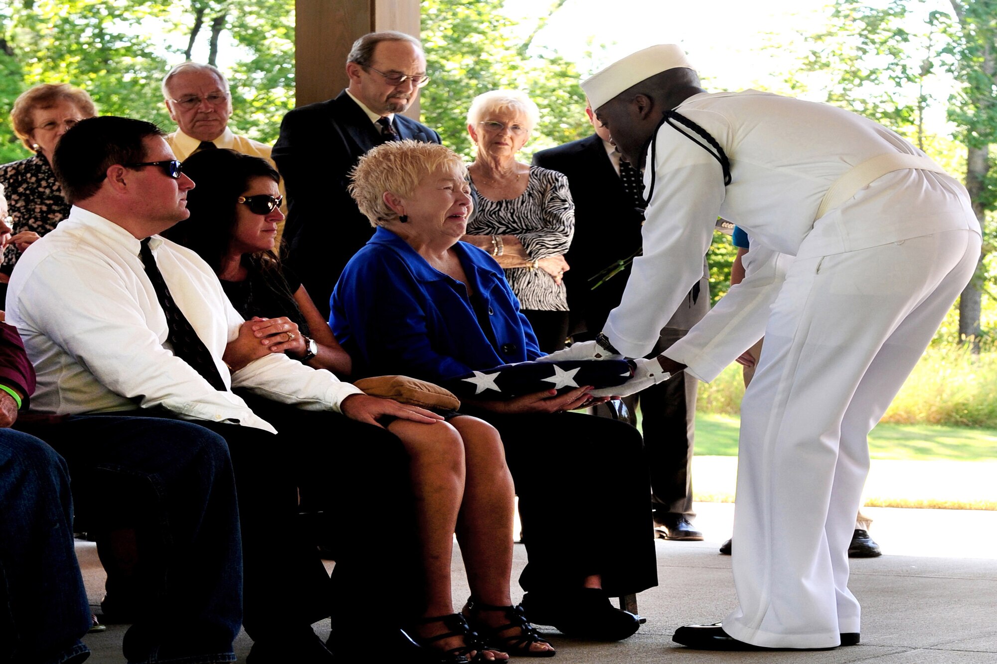 U.S. Navy Petty Officer 3rd Class, Ron Carter, presents a folded U.S. flag to the wife of Solon Merritt  in honor of her and her husband's service during a joint funeral service held Aug. 22, 2012 at the Alabama National Cemetary near Birmingham Ala. Airmen from the Maxwell Air Force Base Honor Guard joined the seaman to offer respects during the ceremony. (U.S. Air Force photo by Master Sgt. Michael Voss)