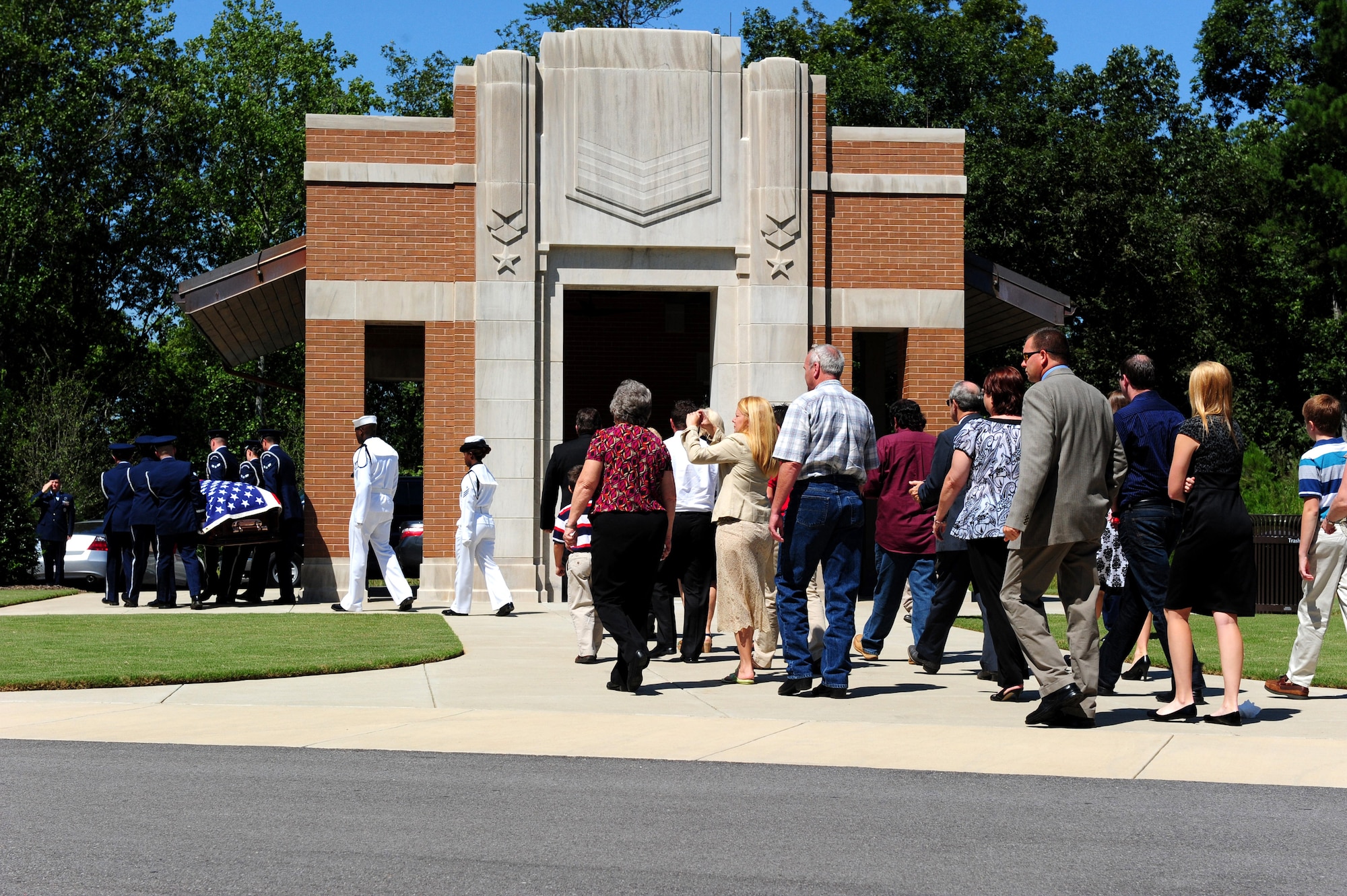 Members of the Maxwell Air Force Base Honor Guard and Navy Honor members are followed by members of the  family during a memorial ceremony held Aug. 22, 2012 at the Alabama National Cemetary in Montevallo Ala. Although Mr. was U.S. Naval veteran, Honor Guard Airmen participate in joint service funerals around the globe. (U.S. Air Force photo by Master Sgt. Michael Voss) 