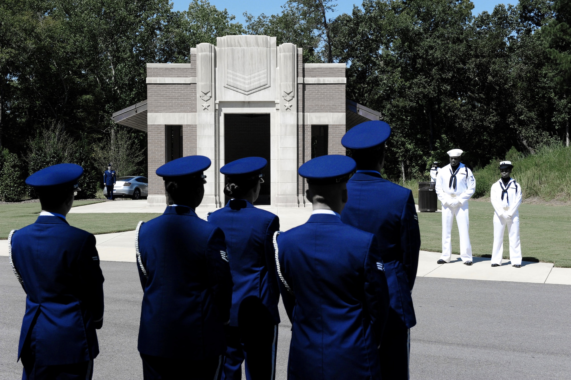 Members of the Maxwell Air Force Base Honor Guard and Navy Honor members are followed by members of the  family during a memorial ceremony held Aug. 22, 2012 at the Alabama National Cemetary in Montevallo Ala. Although Mr. was U.S. Naval veteran, Honor Guard Airmen participate in joint service funerals around the globe. (U.S. Air Force photo illustration by Master Sgt. Michael Voss)