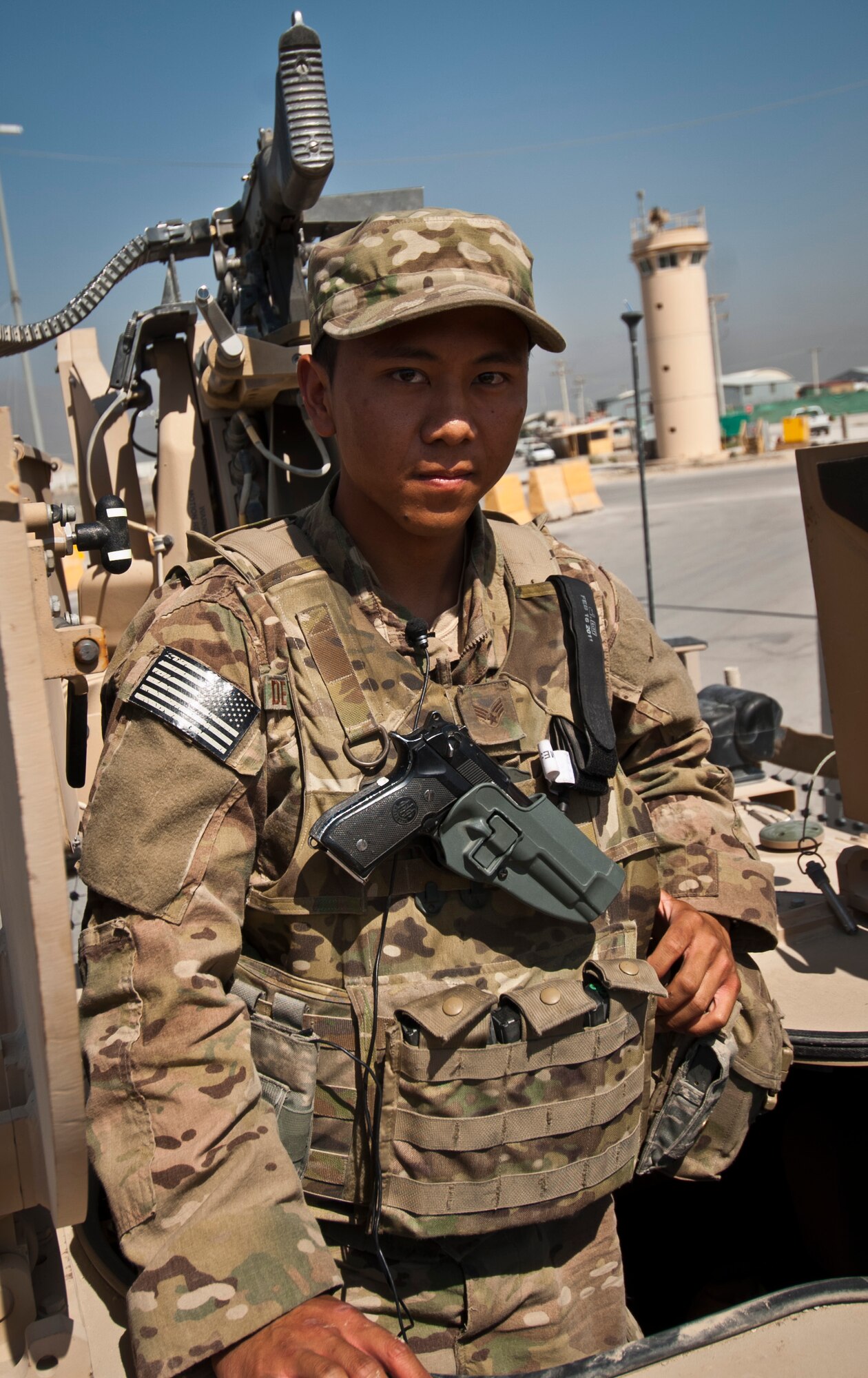 SrA Arsenio De la Cruz, a gunner with the 455th Expeditionary Security Forces Squadron, poses for a photo in front of a Crew Operated Weapons System before a mission at Bagram Airfield Afghanistan, Aug. 18, 2012. The CROW system allows De la Cruz to engagement threats from within the safety of his Mine Resistant Ambush Protected-All Terrain Vehicle. (U.S. Air Force Photo/Capt. Raymond Geoffroy)