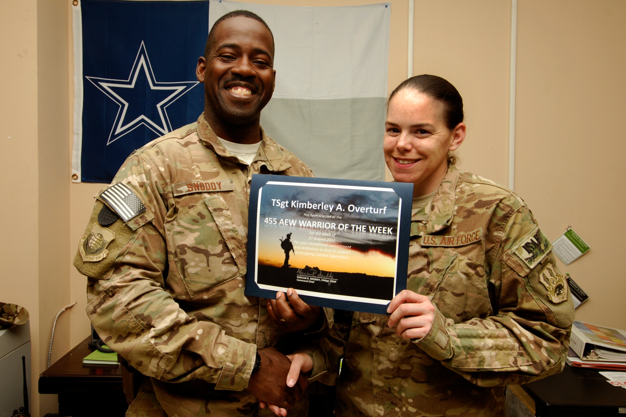 CMSgt Marcus Snoddy, 455th Air Expeditionary Wing command chief, presents the Warrior of the Week award to TSgt Kimberley Overturf, 455 AEW Command Post NCOIC of Console Operations, at Bagram Airfield, Afghanistan, Aug. 30, 2012. Overturf is responsible for maintaining the 455 AEW wing commander’s command and control node. Additionally, TSgt Overturf is accountable for the immediate receipt and dissemination of the wing commander’s notifications and higher headquarters reporting. (U.S. Air Force photos/SSgt Jeff Nevison)