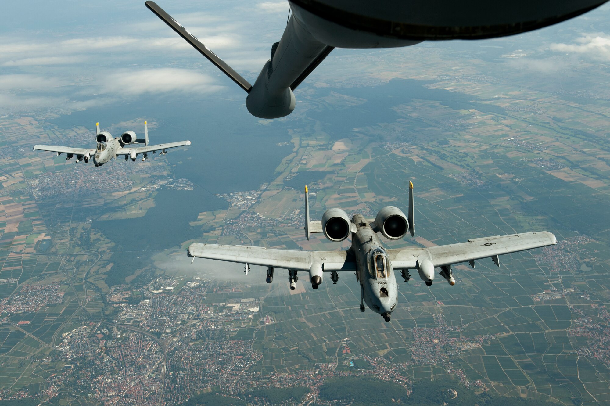 SPANGDAHLEM AIR BASE, Germany – A-10 Thunderbolt II aircraft from the 81st Fighter Squadron fly in formation here Aug. 30 behind a 351st Air Refueling Squadron KC-135 Stratotanker from Royal Air Force Mildenhall, England, after refueling during an orientation flight for 52nd Fighter Wing spouses. The flight allowed spouses to get an up-close view of 81st FS aircraft from Spangdahlem AB during in-flight refueling. The 351st ARS and 52nd FW aircrew train together to enhance their interoperability to perform in-flight refueling missions. (U.S. Air Force photo by Airman 1st Class Dillon Davis/Released)