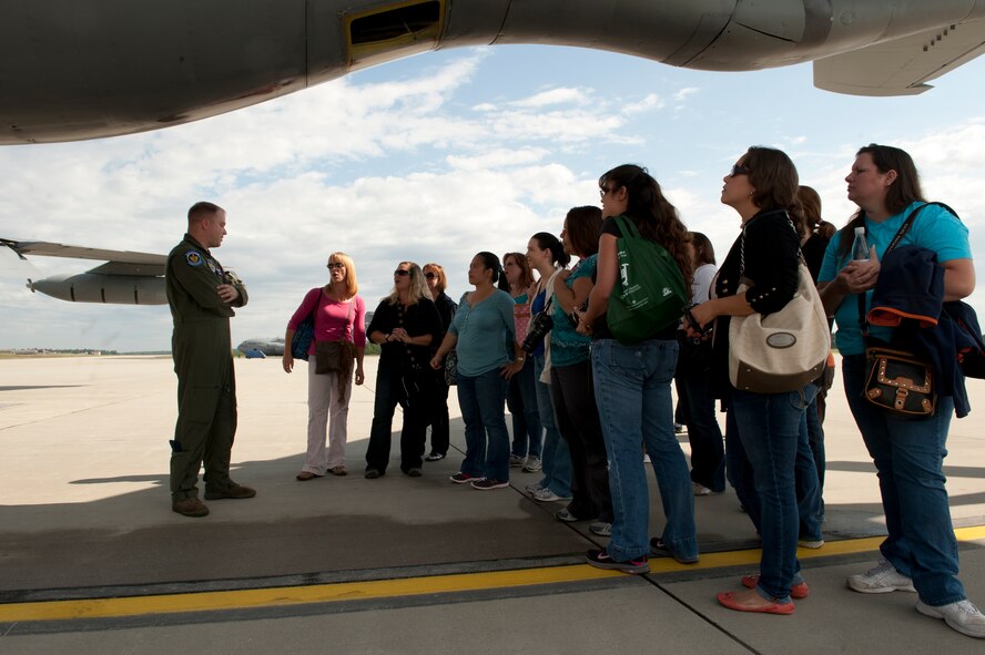 SPANGDAHLEM AIR BASE, Germany – Tech. Sgt. Jonathan Taylor, left, 351st Air Refueling Squadron boom operator, talks to 52nd Fighter Wing spouses here Aug. 30 about the functions of a KC-135 Stratotanker from the 351st Air Refueling Squadron at Royal Air Force Mildenhall, England before an orientation flight. The flight allowed spouses to get an up-close view of in-flight refueling of 81st Fighter Squadron aircraft from Spangdahlem AB. The 351st ARS and 52nd FW aircrew train together to enhance their interoperability to perform in-flight refueling missions. (U.S. Air Force photo by Airman 1st Class Dillon Davis/Released)