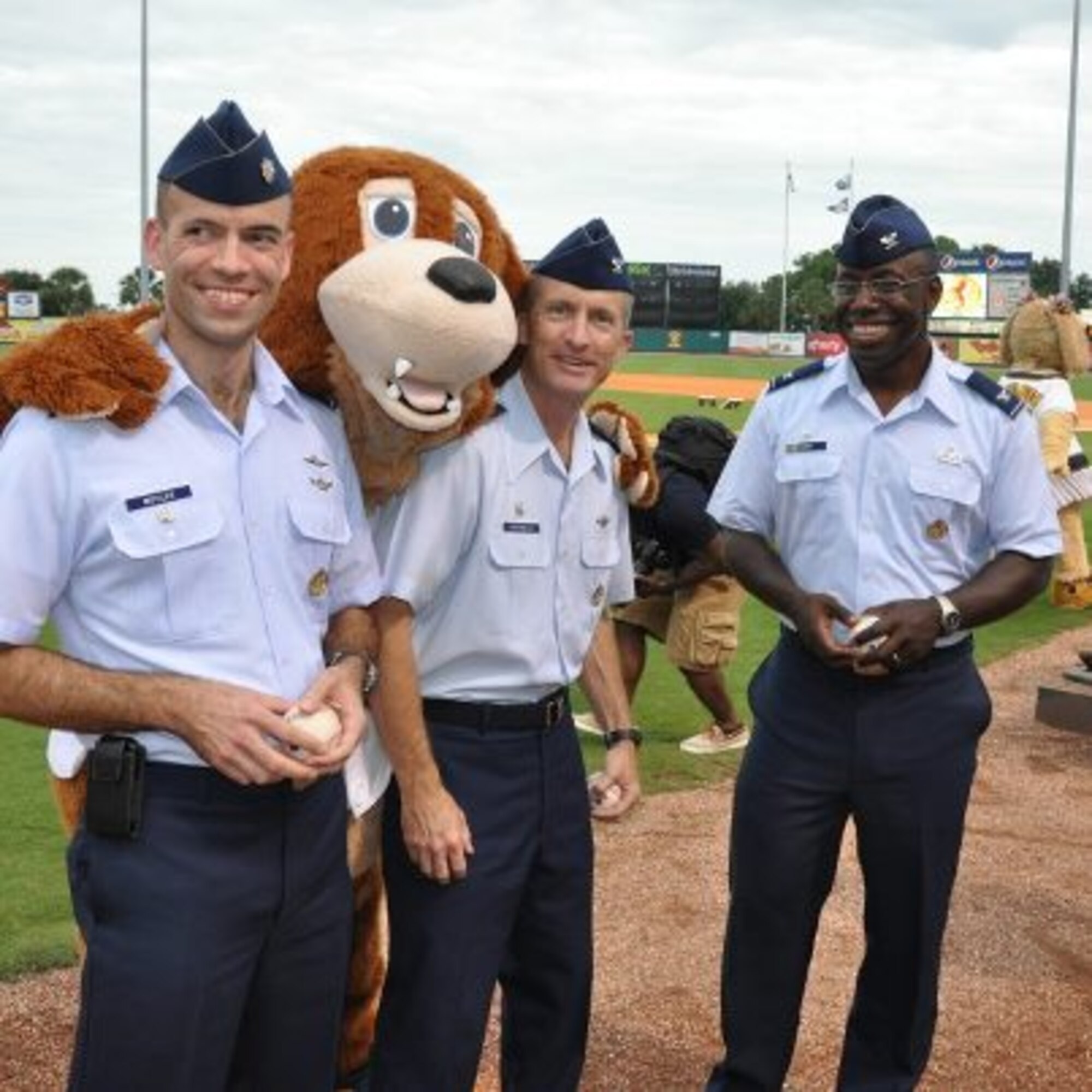 Incoming 315th Airlift Wing Commander, Col. Jamie Fontanella (center) throws out the first pitch  at the Charleston Riverdogs game Aug. 29. He was joined by Col. Dennis Dabney, 437th Maintenance Group commander, and Lt. Col. Michael Moyles, 628th Mission Support Squadron deputy commander. The Riverdogs invited the Joint Base Charleston leaders to help kick off the team's military appreciation night, which was rained out last week. (U.S. Air Force photo / Capt. Wayne Capps)