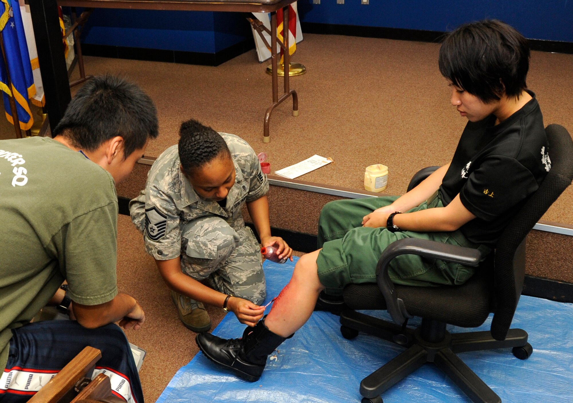U.S. Air Force Master Sgt. Mignon Gullatte, 35th Medical Group aerospace medical squadron superintendent, gives moulage injuries to Japan Air Self-Defense Force volunteers at Misawa Air Base, Japan, in preparation for the Major Accident Response Exercise Aug. 30, 2012. The MARE was initiated to test the base’s ability to respond to a Mass casualty incident such as a plane crash. (U.S. Air Force photo by Airman 1st Class Kaleb Snay/Released)
