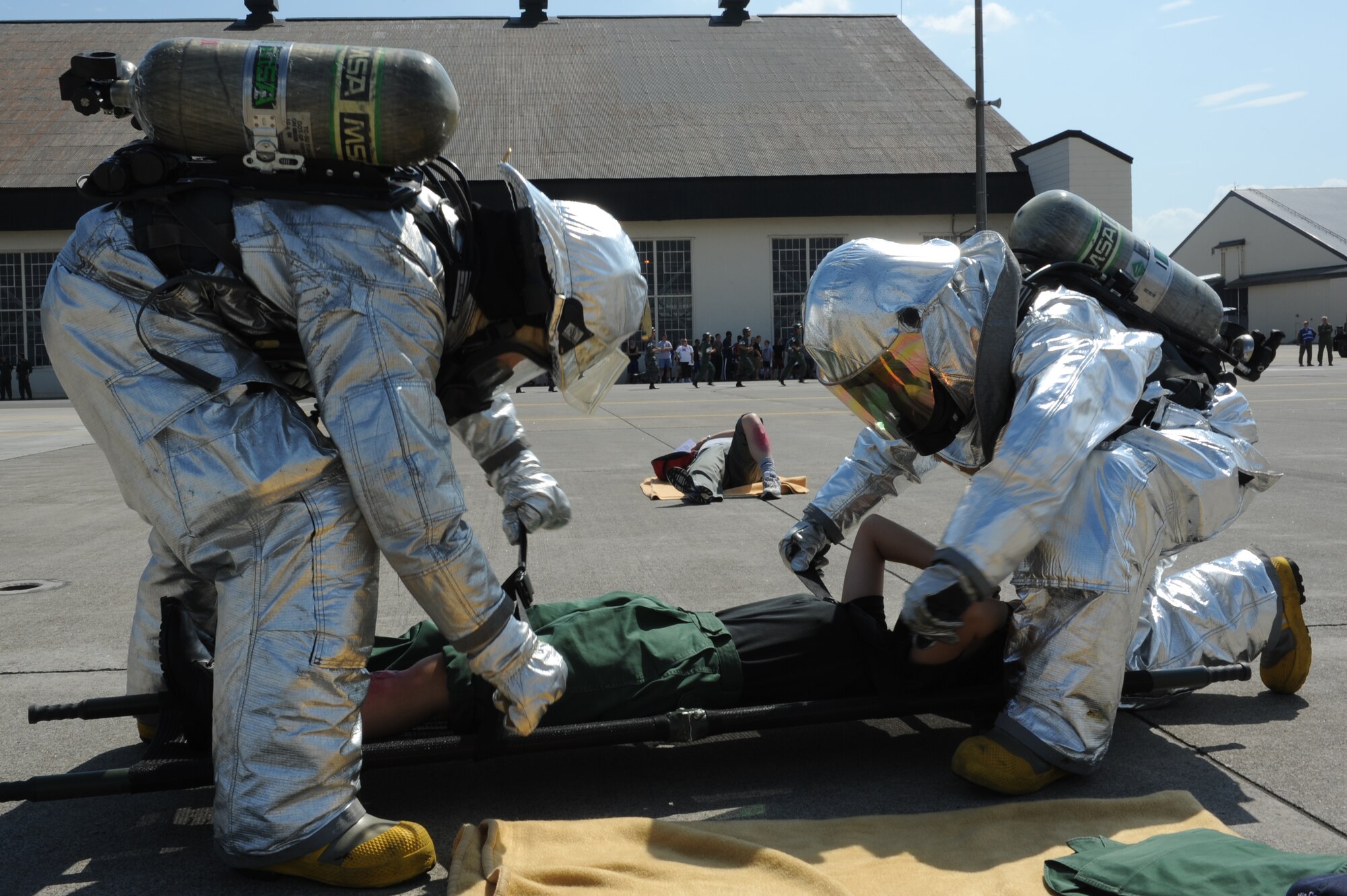 U.S. Air Force firefighters from the 35th Civil Engineer Squadron strap a simulated victim to a stretcher during a major accident response exercise at Misawa Air Base, Japan, Aug. 30, 2012. These types of exercises are used to provide training to improve real-world readiness skills. The MARE helps prepare emergency responders for the possibility of a real-world accident during the upcoming Misawa Air Festival.  (U.S. Air Force photo by Airman 1st Class Kia Atkins/Released)