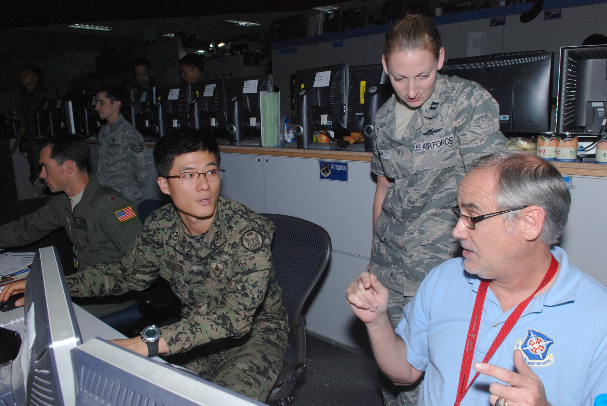 Members of the Combined Air Operations Center, (from left) 1Lt Lee, Sung Min, AFOC, Capt Isaitlin Kenny, HQ AFSOC/A6, David "Freddy"" Kroeger, 623 AOC, discuss air operations during Exercise Ulchi Freedom-Guardian 2012.  The annual computer-simulated, U.S. Combined Forces Command defense-oriented exercise provides valuable training designed to evaluate and improve combined and joint coordination, procedures, plans and systems necessary for the conduct of contingency
operations in defense of Republic of Korea. U.S. Air Force photo by TSgt
Amber Monio, 7th Air Force Public Affairs
