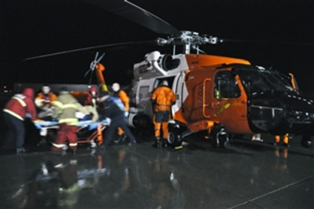 Coast Guard crew members and emergency medical personnel transfer a patient to an ambulance from a Coast Guard Air Station Sitka MH-60 Jayhawk helicopter at the Alaska Air National Guard hangar in Juneau, Alaska, Aug. 28, 2012. The patient was medevaced from Skagway, Alaska, after suffering from cardiac and respiratory failure.
