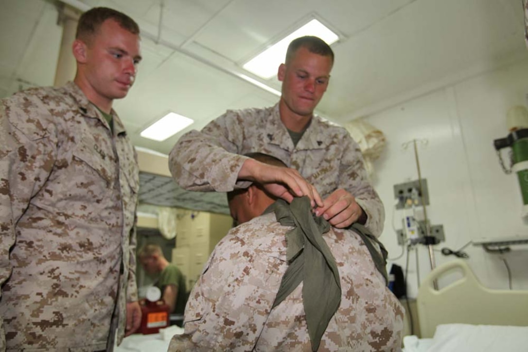 Marines from the 15th Marine Expeditionary Unit practice applying arm carriages during a Combat Life-saving Skills course aboard the USS Rushmore, Aug. 23. The four-day course teaches Marines how to give basic level care in order to prevent the loss of casualties on the battlefield.