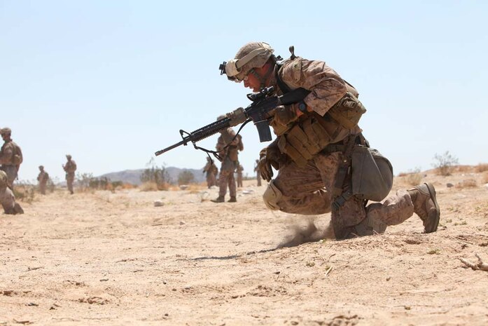 Lance Cpl. Luis Garces, rifleman, Company B, 1st Battalion, 4th Marine Regiment, kneels to the ground while conducting buddy rushes on Range 105, Aug. 14. Approximately 150 Marines visited the Combat Center from Marine Corps Base Camp Pendleton, Calif., as part of the Tactical Small Unit Leaders Course.