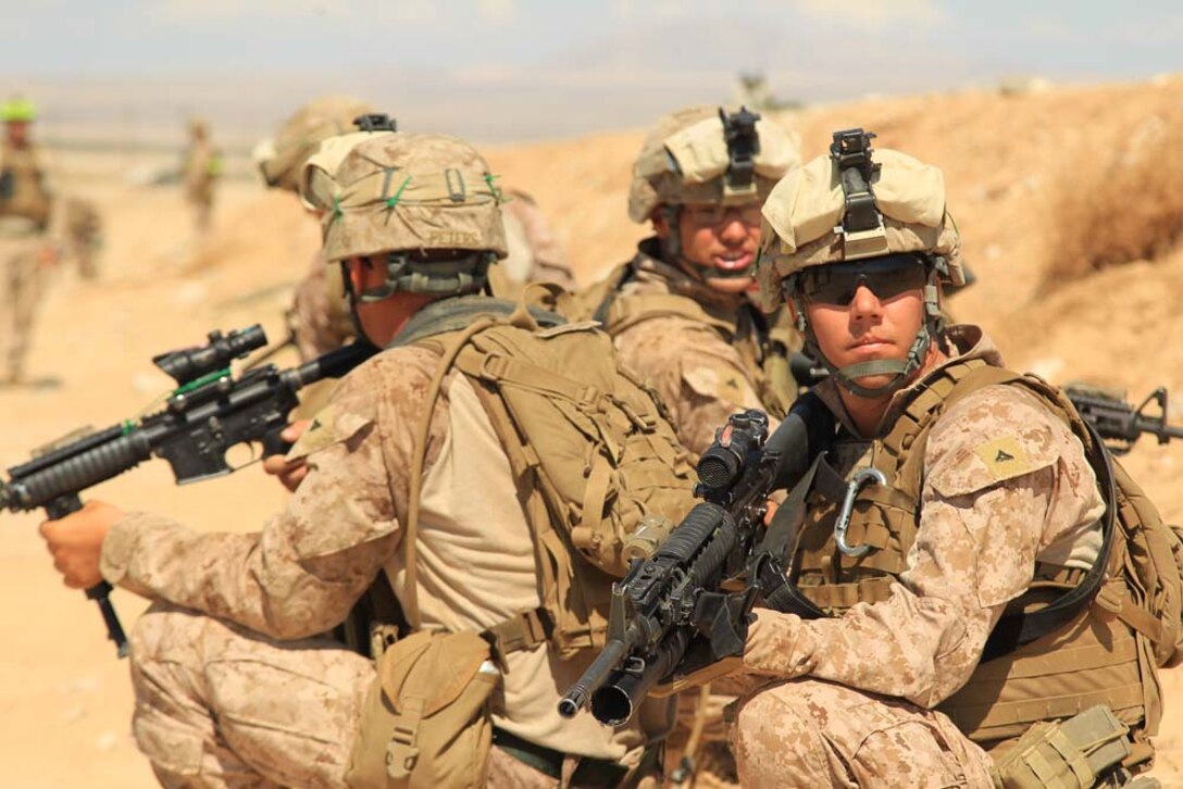 Lance Cpl. Cosmo Peters, machine gunner, 1st Battalion, 4th Marine Regiment, and his fire team prepare to rush over the berm and take down a bunker approximately 100 meters down Range 105, Aug. 18, 1012.