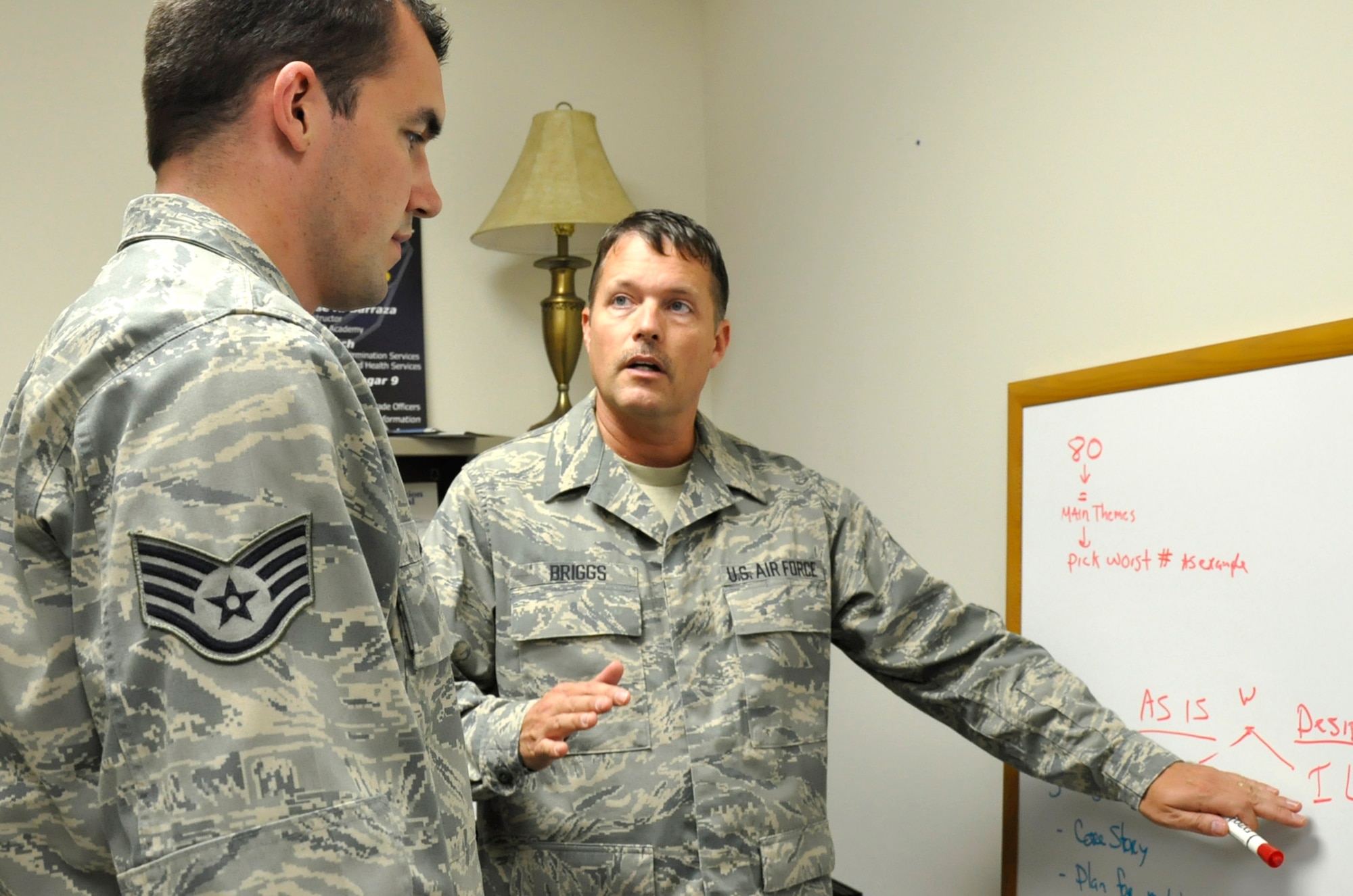 Master Sgt. James Briggs (center), 446th Airlift Wing Equal Opportunity Office superintendent, walks Staff Sgt. Joseph Jensen through some on-the-job training at the 446th EO Office here, Aug. 31, 2012. The 446th EO mission is to equip and educate Reservists on the importance of proper human relations in their work area including mediation, consultations, and communication strategies. (U.S. Air Force photo by Master Sgt. Jake Chappelle) 