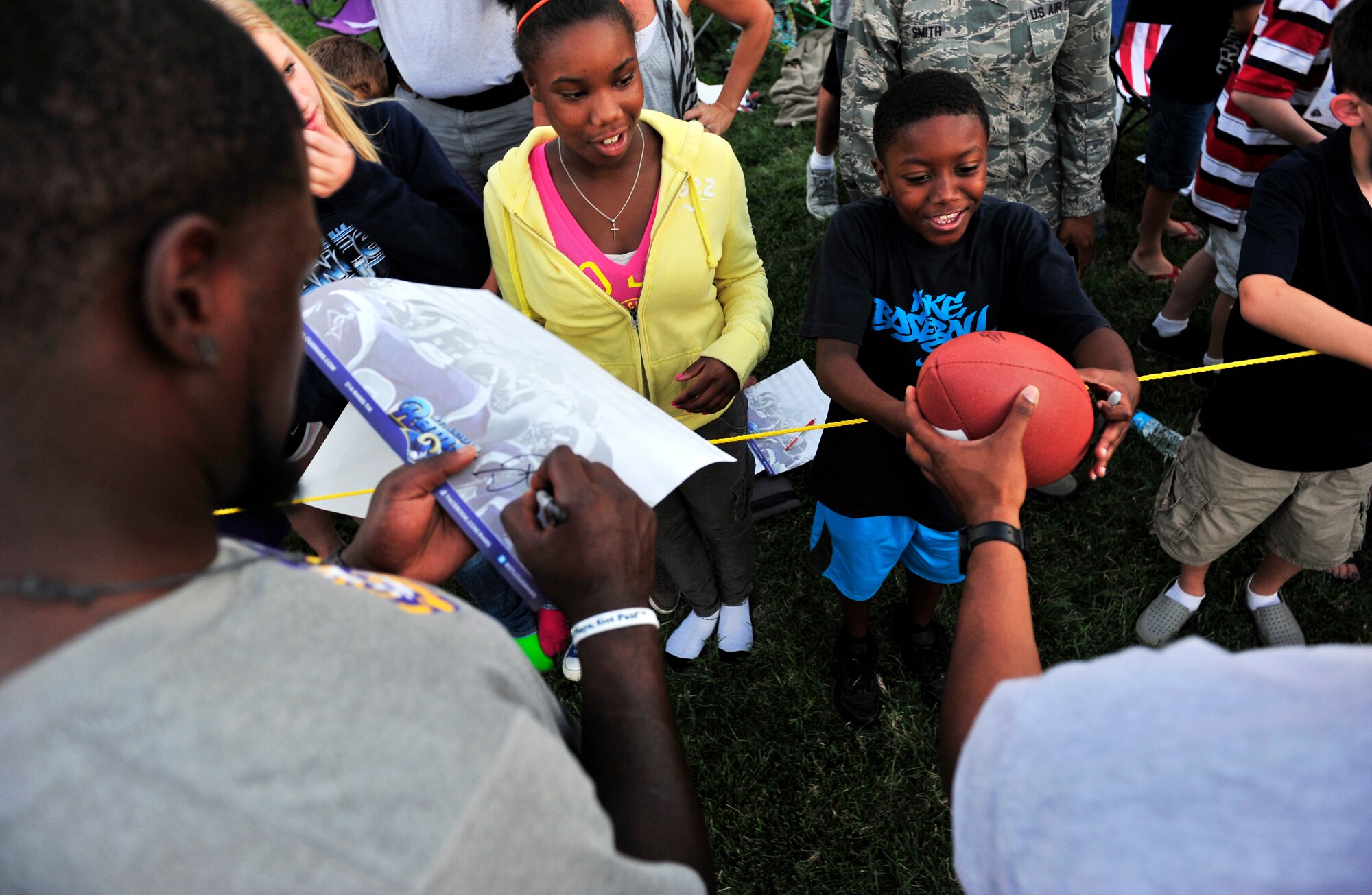 Members of the St. Louis Rams special teams unit sign autographs after a walk through practice Aug. 29 at Scott Air Force Base, Ill. Military members received a rare opportunity to play in a practice walk through against professional football players. (U.S. Air Force photo/Staff Sgt. Stephenie Wade)