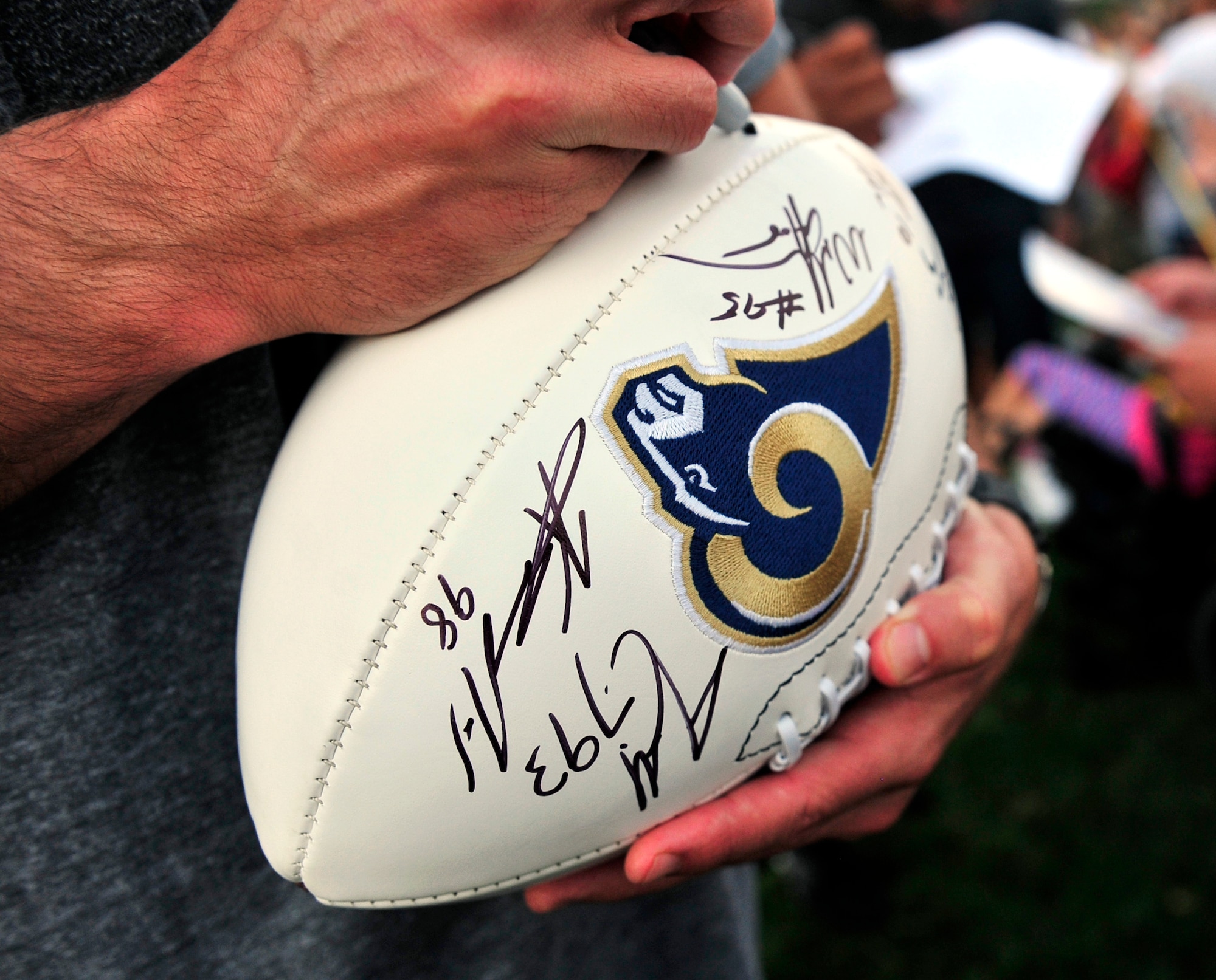 Members of the St. Louis Rams special teams unit sign autographs after a walk through practice Aug. 29 at Scott Air Force Base, Ill. Military members received a rare opportunity to play in a practice walk through against professional football players. (U.S. Air Force photo/Staff Sgt. Stephenie Wade)