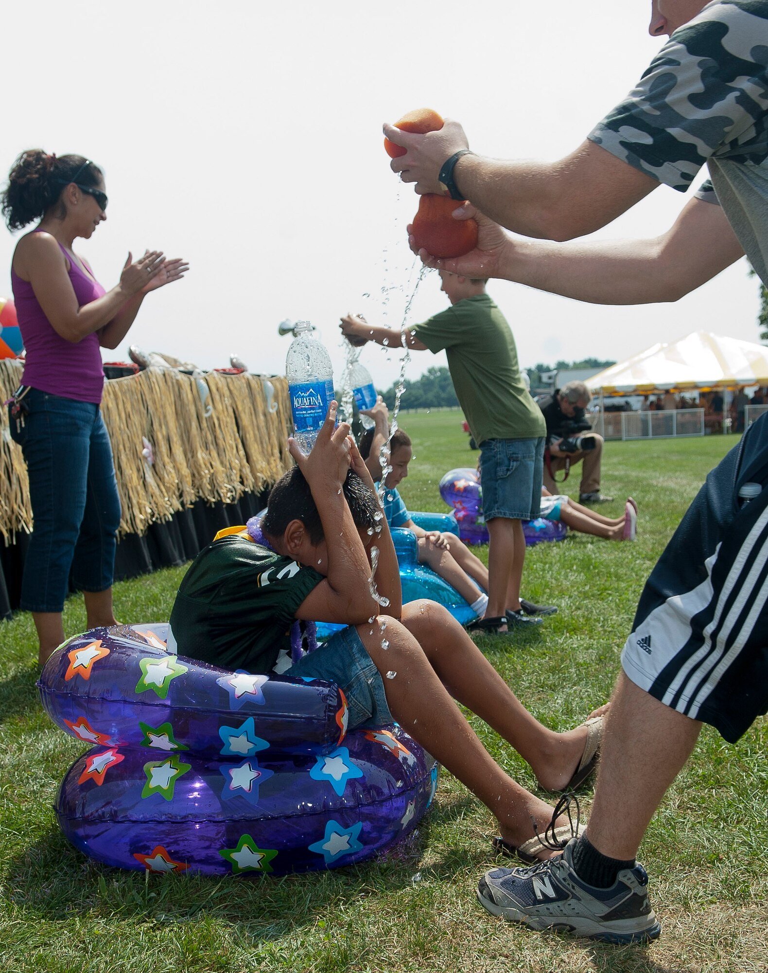 Competitors at the Joint Base McGuire-Dix-Lakehurst Annual Summer Picnic engage in the water relay Aug. 24 on Doughboy Field here. The goal was to fill a bottle on top a team member's head with just water from a sponge. (U.S. Air Force photo by Wayne Russell/Released)