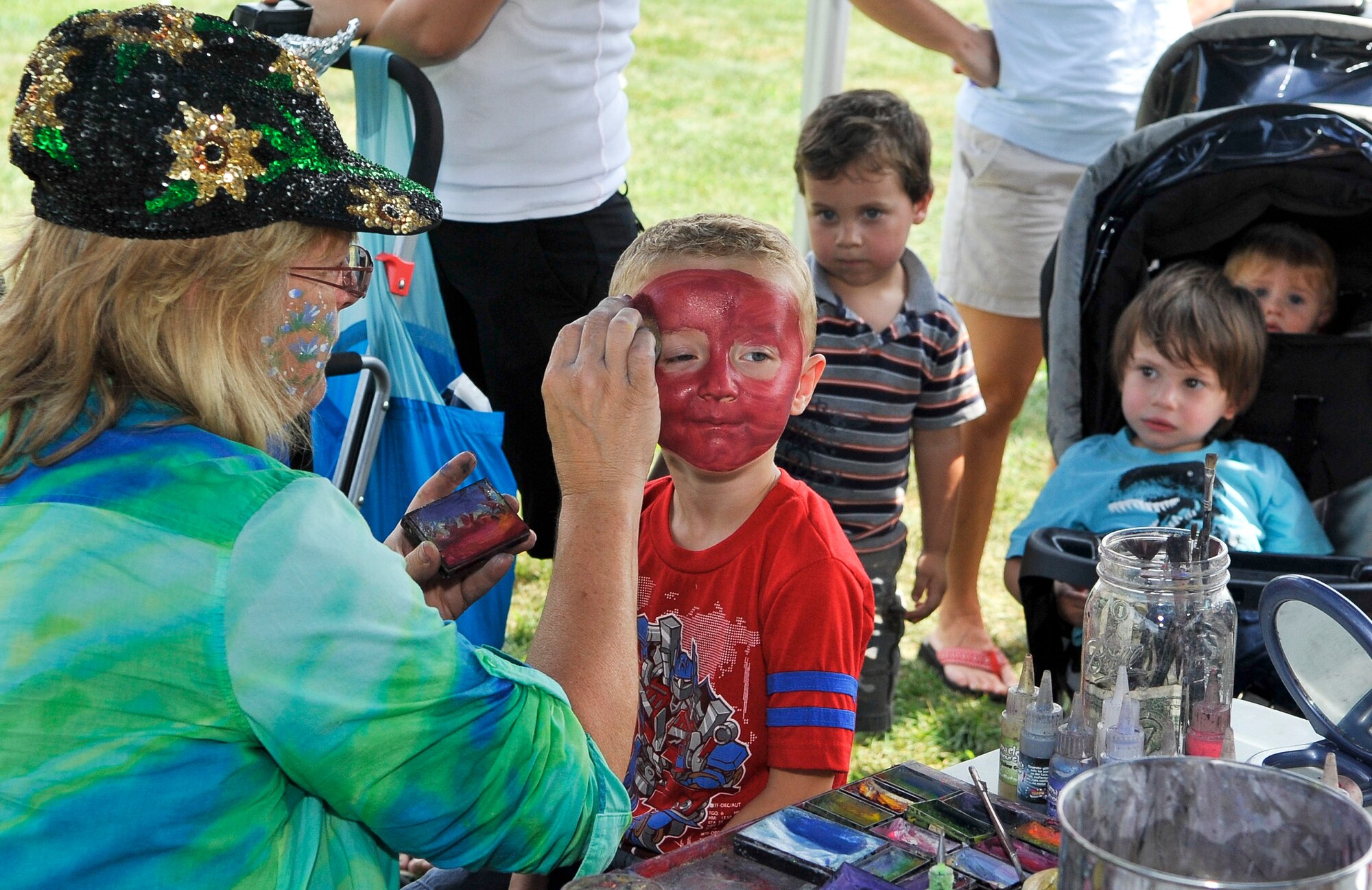 Dylan Phile, 4, son of Capts. Laura and Dennis Phile, 76th Air Refueling Squadron executive officer and 108th Air Refueling Wing maintenance officer respectively, has red face paint applied for his Spiderman make-up Aug. 24 by Cheryl Currier during the Joint Base McGuire-Dix-Lakehurst Annual Summer Picnic on Doughboy Field here. (U.S. Air Force photo by Wayne Russell/Released)