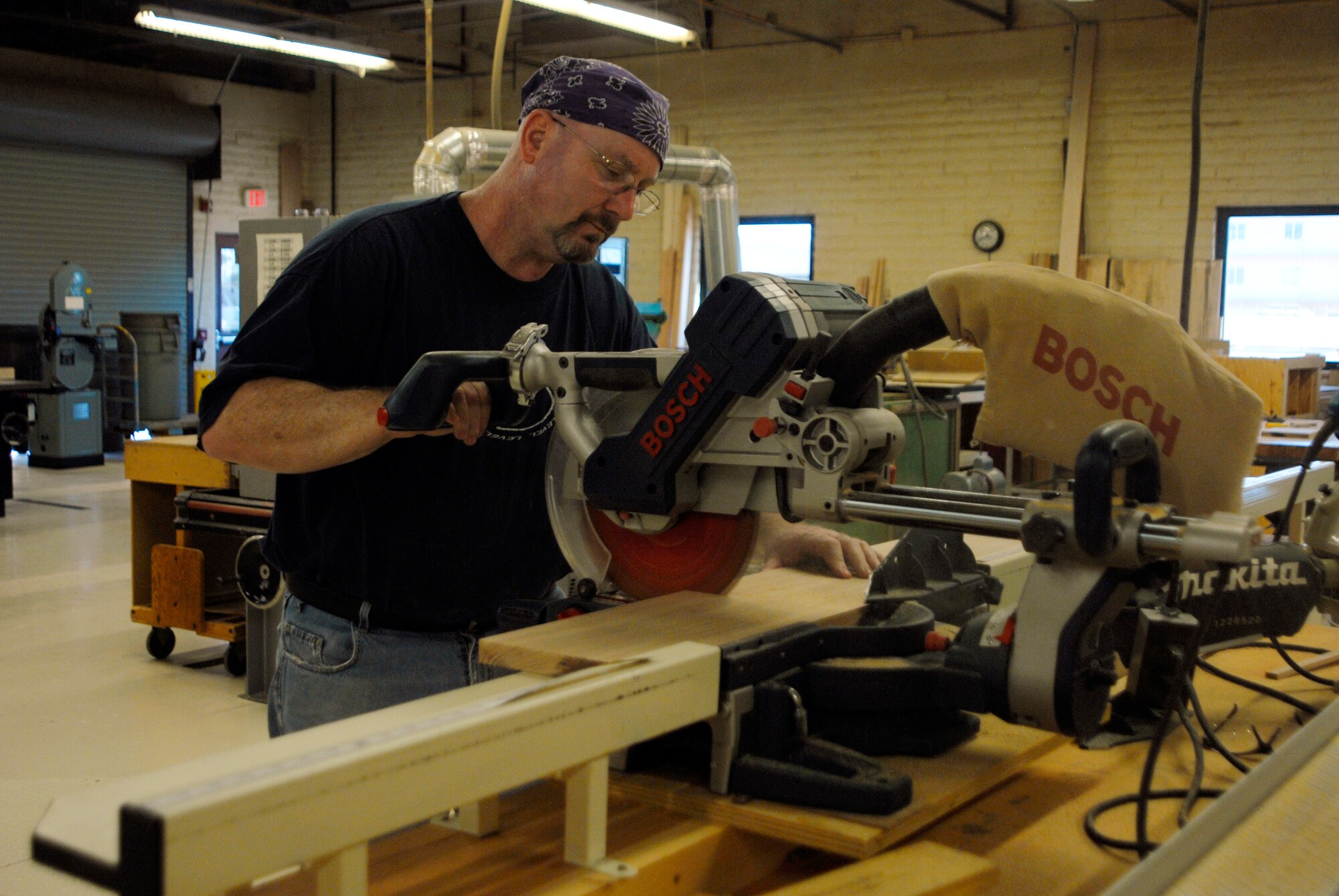 Charles Jennings, retired master sergeant, cuts wood for a gate he is building using a chop saw at the Luke Air Force Base Wood Hobby Shop.  Jennings has saved money and enjoyed a hobby while building several household items.  (U.S. Air Force photo by Airman 1st Class David Owhianka)