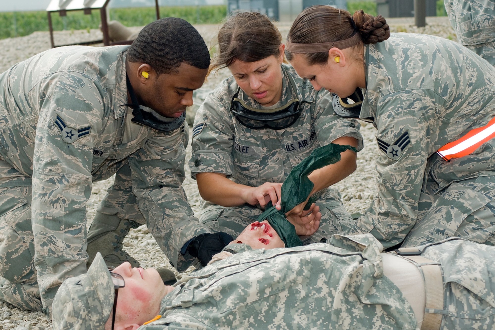 GRISSOM AIR RESERVE BASE, Ind. -- U.S. Air Force Reserve Airman 1st Class Brent Cannon, Senior Airman Kandi DeLee and Senior Airman Brittany Ridge tend to a U.S. Army Reserve Soldier's simulated wounds during a joint forces exercise held here Aug. 5. The exercise allowed 434th Aerospace Medicine Squadron aeromedical technicians to practice life-saving skills under a high-stress scenario. (U.S. Air Force photo/Tech. Sgt. Mark R. W. Orders-Woempner)
