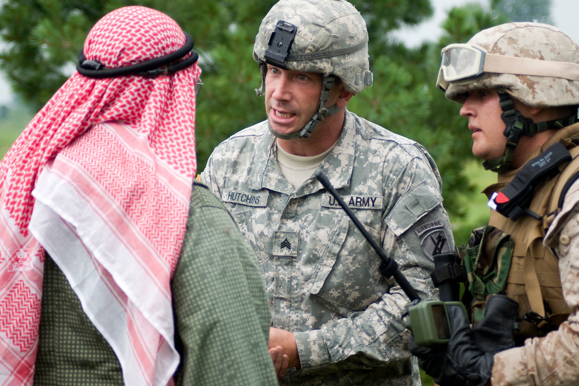 GRISSOM AIR RESERVE BASE, Ind. -- U.S. Army Reserve Sgt. Mark Hutchins, 316th Psychological Operations Company, talks with a village leader during a joint forces exercise here Aug. 5 as U.S. Marine Corps Reserve Cpl. Daniel Lewis listens. Lewis is assigned to Detachment 1, Communications Company, Headquarters and Service Battalion, 4th Marine Logistics Group here. (U.S. Air Force photo/Tech. Sgt. Mark R. W. Orders-Woempner)
