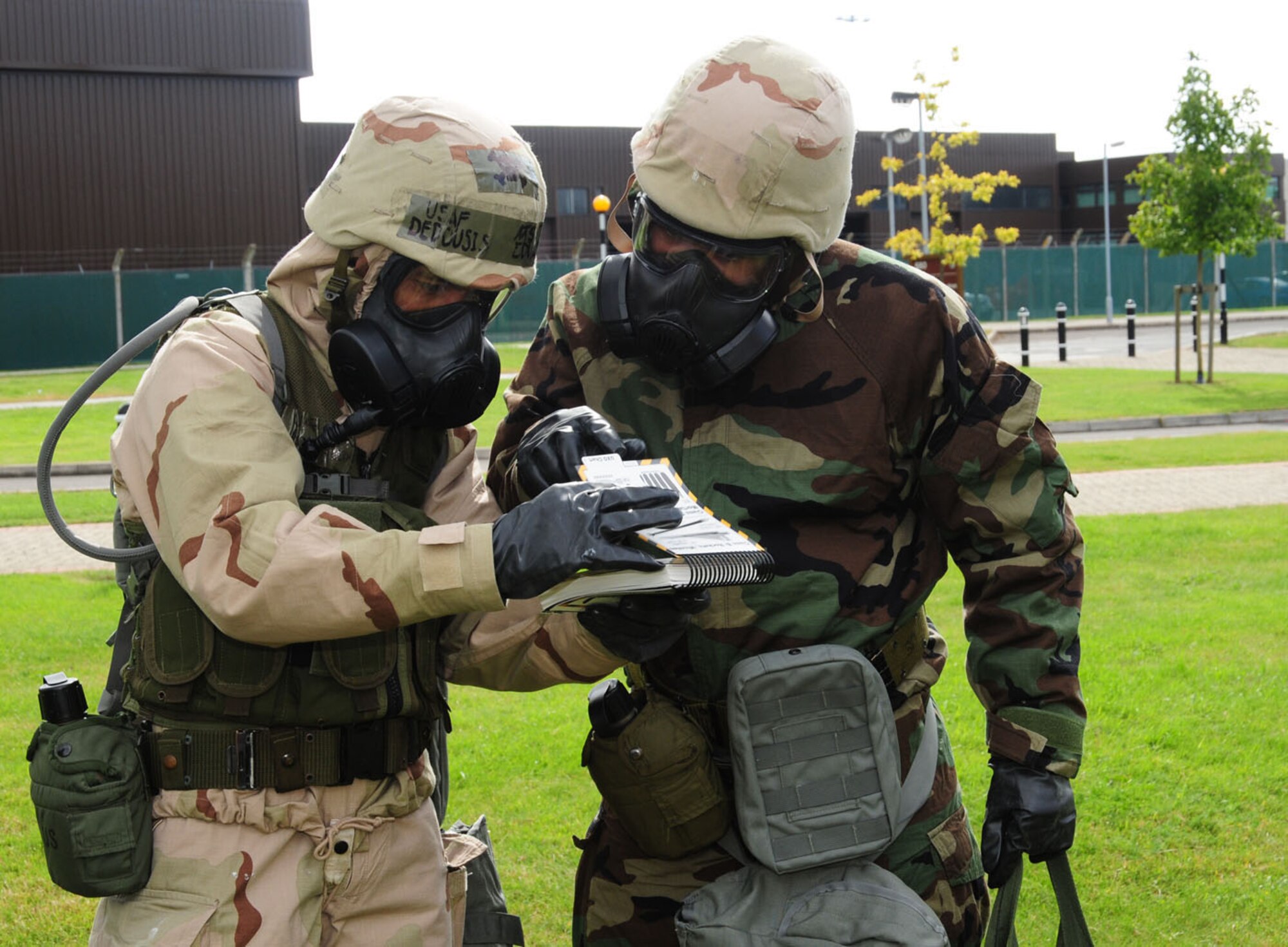 RAF MILDENHALL, England – Master Sgt. Edward Dedousis, left, and Tech. Sgt. James White, both 100th Logistics Readiness Squadron, check the Airman’s Manual after finding a simulated unexploded ordnance during ability to survive and operate training Aug. 28, 2012, at Bldg. 680, RAF Mildenhall. Military members from the 100th Air Refueling Wing took part in the training, which also included self-aid and buddy care, contamination control area and post-attack reconnaissance. (U.S. Air Force photo/Karen Abeyasekere)
