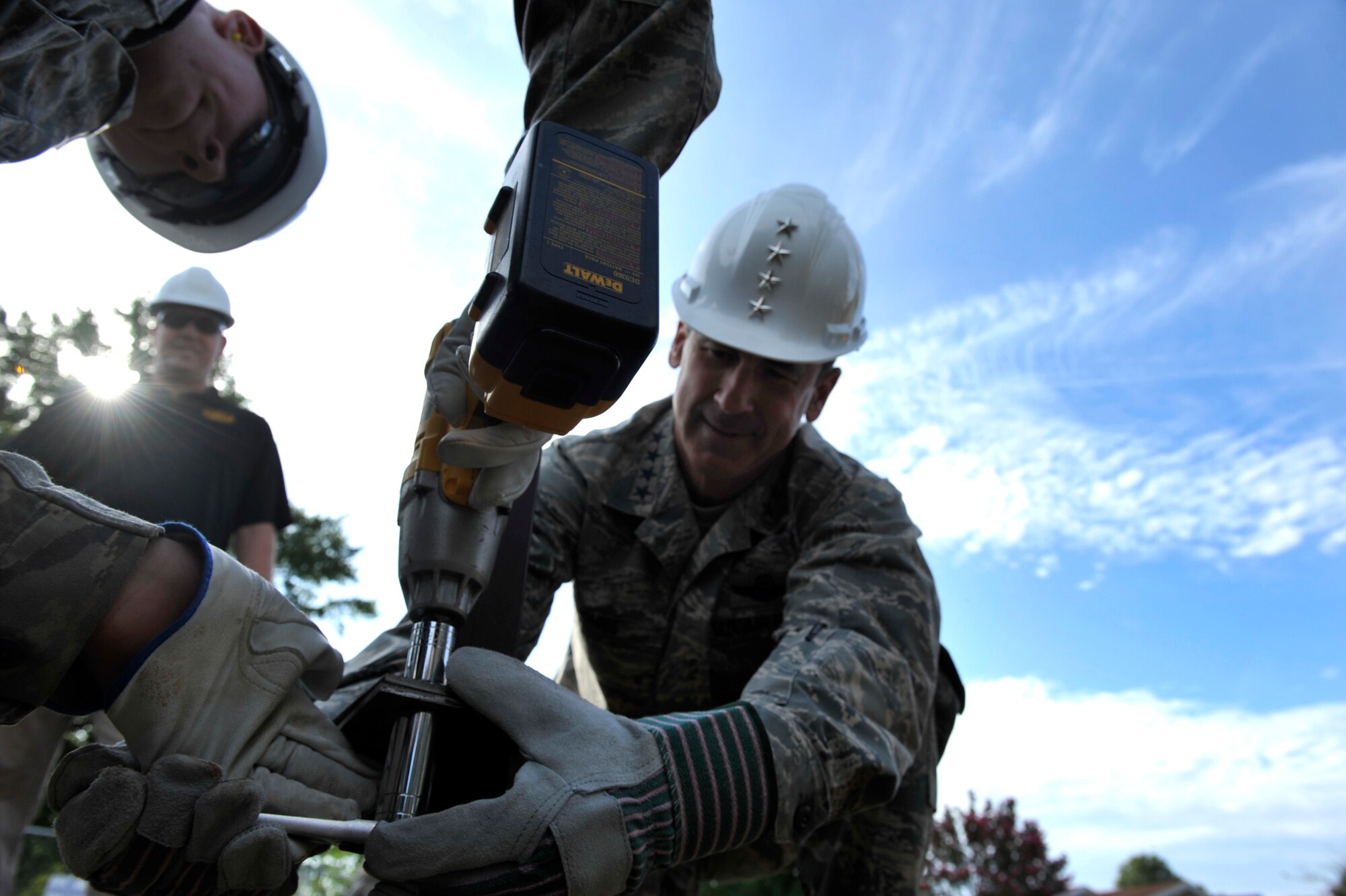 Gen. Raymond Johns, Air Mobility Command commander, helps stand up the “77 Acres” sign in base housing Aug. 30, 2012, at Little Rock Air Force Base, Ark. The “77 Acres” sign is the beginning of the project designed to develop a new joint education campus. (U.S. Air Force photo/Airman 1st Class Rusty Frank)