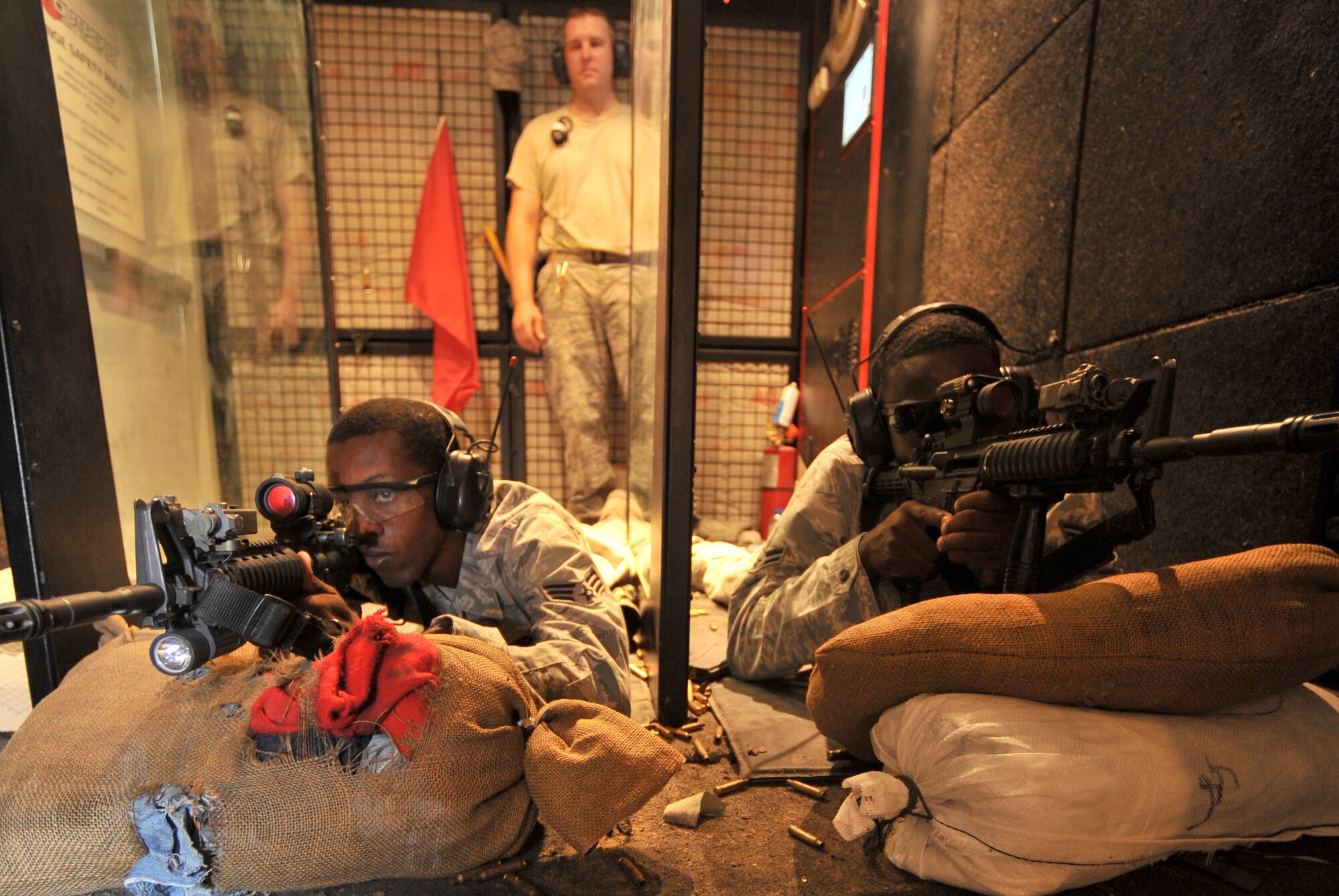 SOUTHWEST ASIA - U.S. Air Force Senior Airman Andre McCoo and Airman 1st Class Kadeem Brisbane, 380th ESFS members, zero their weapons in the mobile firing range here as Staff Sgt. Richard Mulford, 380th Expeditionary Security Forces Squadron Combat Arms Training and Maintenance NCO in charge, watches Aug. 24, 2012. Proper aim is achieved when a weapon is "zeroed," meaning its sights are set specifically to the shooter so the shooter can actively and precisely engage a target. (U.S. Air Force photo/Senior Airman Jared Elliott)