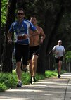 Members of the 8th Fighter Wing run along the road during a triathlon on  Kunsan Air Base, Republic of Korea, Aug. 25. This was the second triathlon this year and had more than 25 participants (U.S. Air Force photo/Staff Sgt. Jonathan Fowler)