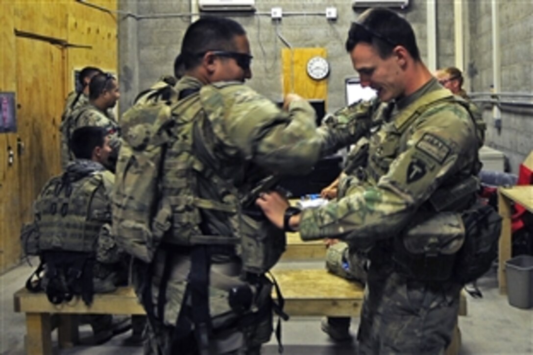 U.S. Army Spc. Nicholas Cerreto, right, helps a fellow soldier prepare on Forward Operating Base Farah before departing for a mission in Farah City in Afghanistan's Farah province, Aug. 29, 2012. Cerreto is assigned to Provincial Reconstruction Team Farah.