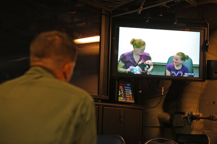 USS IWO JIMA (June 9, 2012) - Corporal David Rohrer, a Louisville, Ohio, Native with the Air Combat Element, 24th MEU, talks to his wife while holding their new born baby,  through a video teleconference aboard the USS Iwo Jima, June 9, 2012. The 24th MEU is deployed with the Iwo Jima Amphibious Ready Group as a U.S. Central Command theater reserve force providing support for maritime security operations and theater security cooperation efforts in the U.S. 5th Fleet area of responsibility. (Official Marine Corps photo by Gunnery Sgt. Chad R. Kiehl)