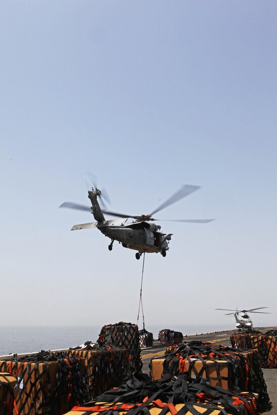 An MH-60S Knighthawk helicopter transports food and supplies from the USNS Rappahannock to the flight deck of USS Iwo Jima during a replenishment at sea detail Aug. 29, 2012. During the RAS the USS Iwo Jima took on fuel, fresh fruits and vegetables, supplies and mail to sustain the ship through the next few weeks. The 24th MEU is deployed with the Iwo Jima Amphibious Ready Group as a theater reserve force for U.S. Central Command and is providing support for maritime security operations and theater security cooperation efforts in the U.S. Navy's 5th Fleet area of responsibility.