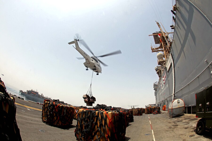A helicopter from the USNS Rappahannock delivers food and supplies to the flight deck of USS Iwo Jima during a replenishment at sea detail Aug. 29, 2012. During the RAS the USS Iwo Jima took on fuel, fresh fruits and vegetables, supplies and mail to sustain the ship through the next few weeks. The 24th MEU is deployed with the Iwo Jima Amphibious Ready Group as a theater reserve force for U.S. Central Command and is providing support for maritime security operations and theater security cooperation efforts in the U.S. Navy's 5th Fleet area of responsibility.