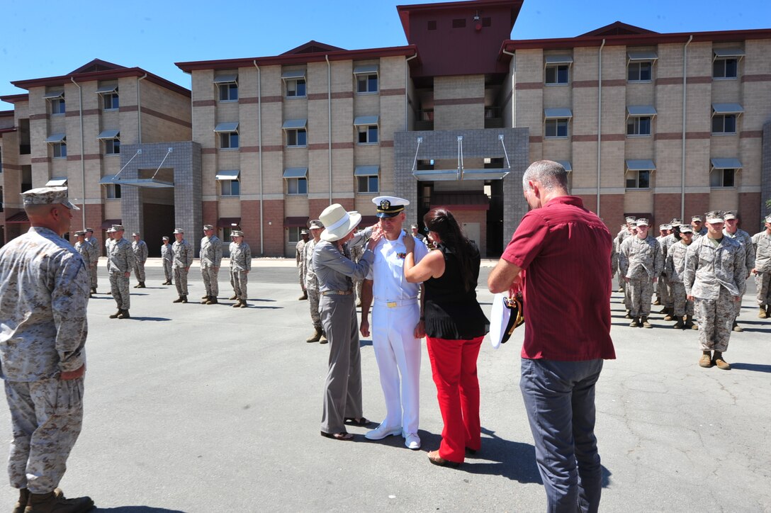 Cmdr. Jon W. Conroe, chaplain with the 11th MEU's command element, receives his new rank from family members during a promotion ceremony here Aug 31. Conroe said that his job is to provide guidance and mentorship to military service members based on a religious faith while facilitating the free exercise of religion. (U.S. Marine Corps photo by PFC Demetrius Morgan/RELEASED)
