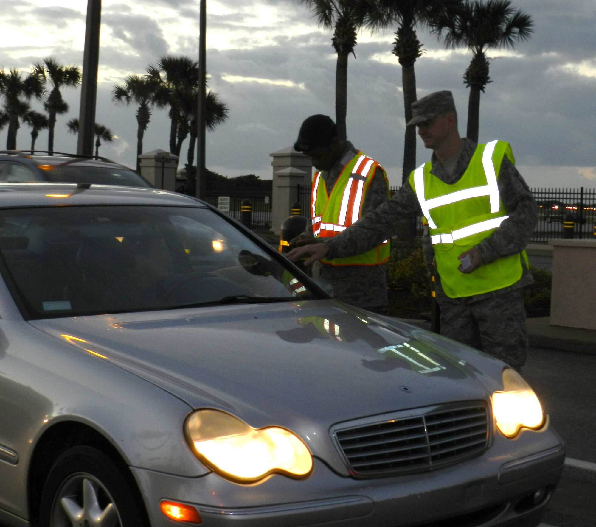 Alongside 920th security forces personnel checking ID cards at the Patrick Air Force Base main gate Dec. 1, members of the 920th Rescue Wing Safety Office hand out safety reminders as Rescue Wing Airmen enter to start their weekend drill training. The safety push is part of a commandwide program to remind all Airmen to act safely when approaching all tasks that go along with the holidays, to include holiday cheer and driving. (U.S. Air Force photo/Capt. Cathleen Snow)