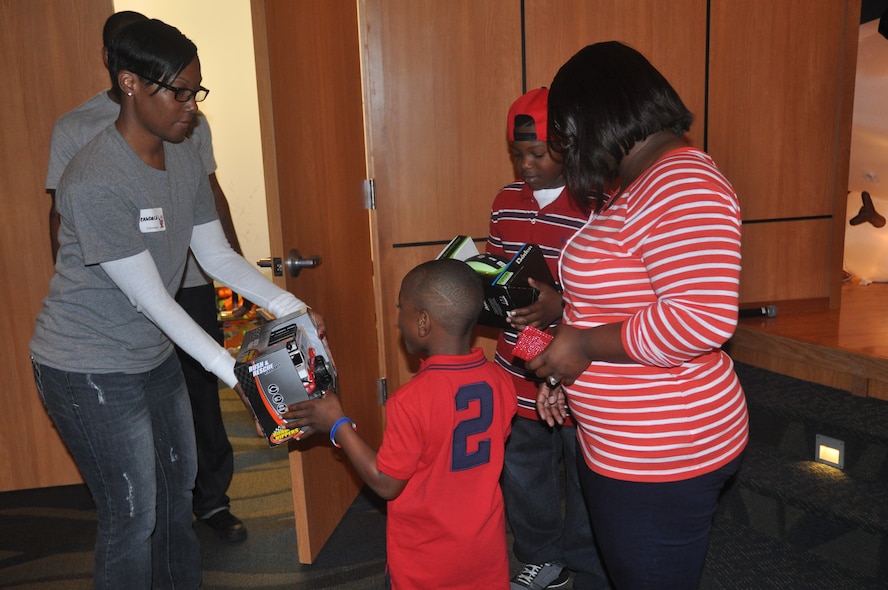 Tech. Sgt. Candace Lefevers, Airey NCO Academy student, helps hand out presents to children at “Breakfast with Santa” Dec. 1. The program, which brings military families together to share in holiday festivities, featured a pancake breakfast for parents and children, arts and crafts, and a meet and greet with Santa Claus.  Approximately 800 military parents and children gathered to celebrate the holiday season on Tyndall during the event. (U.S. Air Force photo by 2nd Lt. Andrea Valencia)