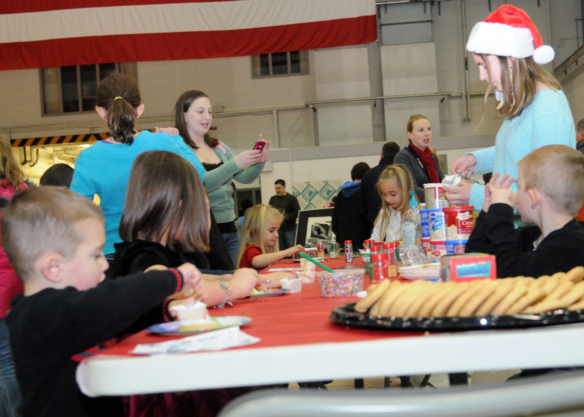 Children decorate Christmas cookies during the 100th Maintenance Group Children's Christmas Party Dec. 1, 2012, at Hangar 803 at RAF Mildenhall, England. The event had many other activities like, a meet and greet with Santa, bouncy castles, coloring and bingo. . (U.S. Air Force photo by Airman 1st Class Kelsey A.L. Waters/Released)