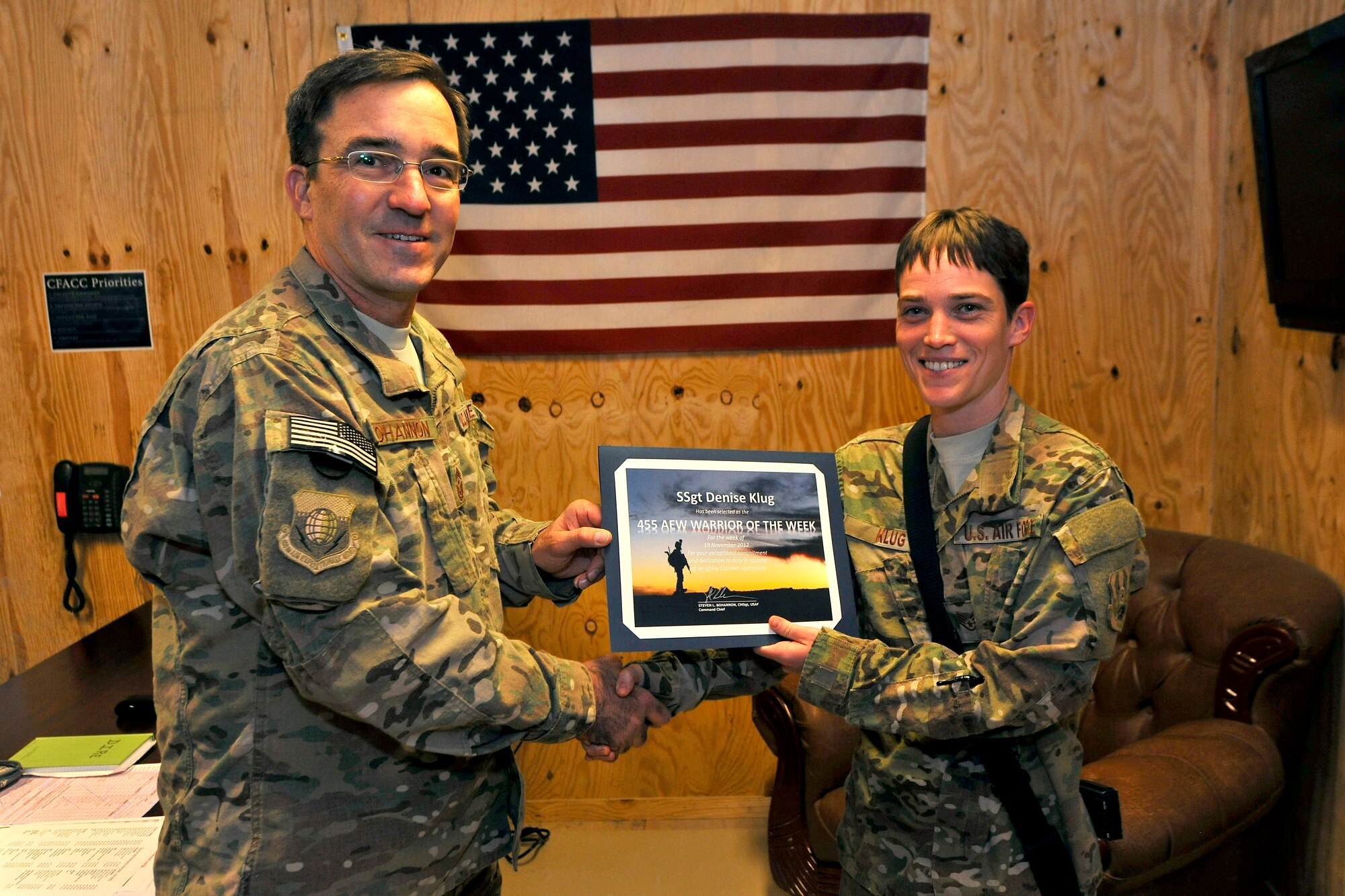 Chief Master Sgt. Steve Bohannon, Command Chief Master Sergeant of the 455th Air Expeditionary Wing, presents the “Warrior of the Week” award to Staff Sgt. Denise Klug, network management NCOIC for the wing’s communications squadron at Bagram Airfield, Afghanistan, Nov. 28, 2012. Klug supervised a special team that increased connectivity on the “MoraleNet,” allowing access to 5,000 more users. (U.S. Air Force photo/Senior Airman Chris Willis)