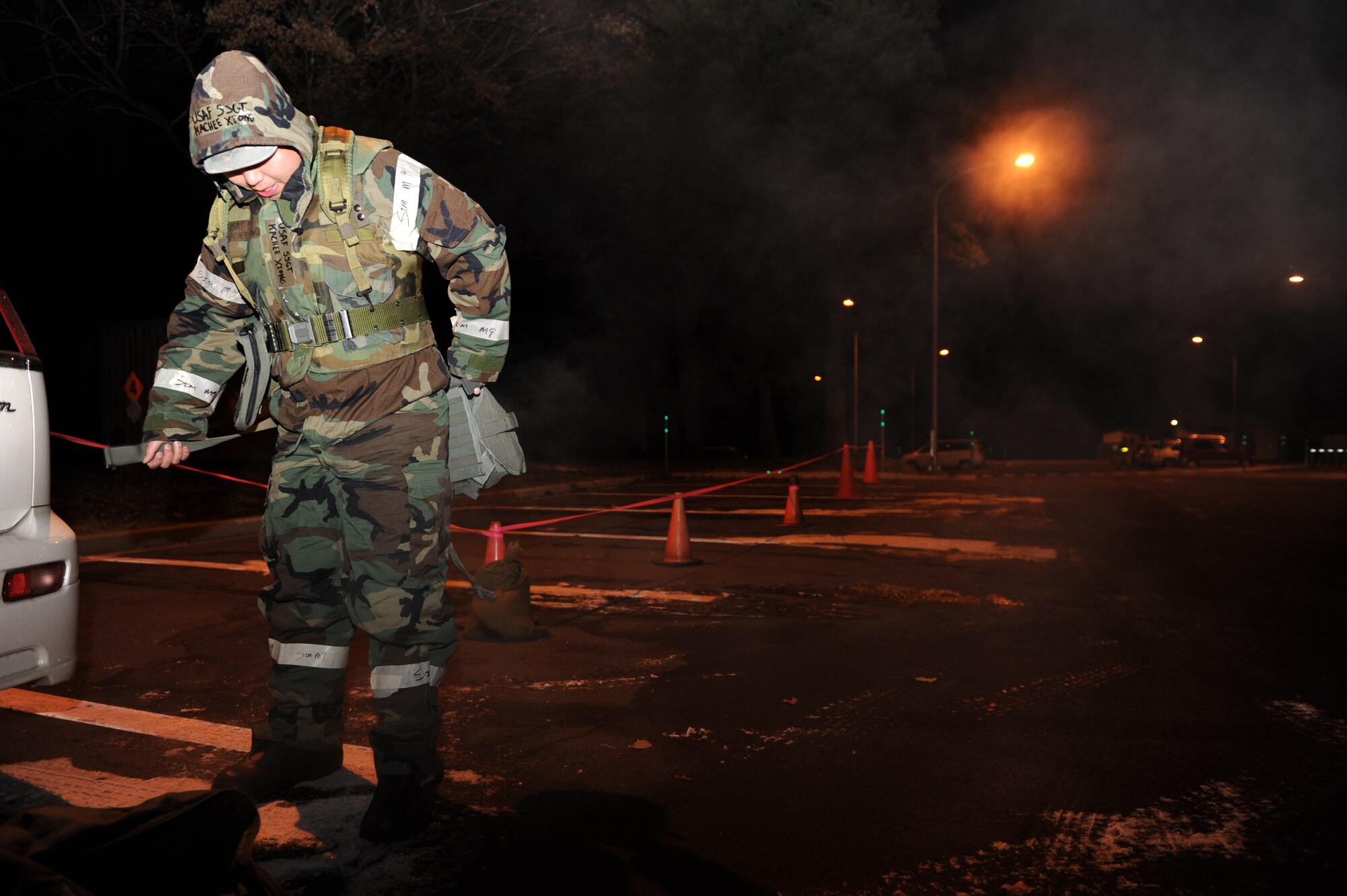 U.S. Air Force Staff Sgt. Kachee Xiong, 35th Communications Squadron base radio and security systems NCO in charge, suits up in his Mission-Oriented Protective Postures gear and straps on his gas mask before processing through the transition line at Misawa Air Base, Japan, Dec. 3, 2012. During Operational Readiness Exercises, Airmen are tested on their mission readiness in preparation for real-world deployments.  (U.S. Air Force Photo by Airman 1st Class Kia Atkins)  
