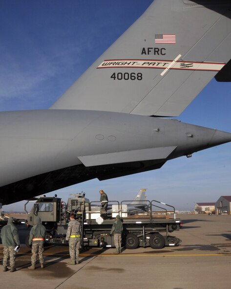 Airmen of the 185th Air Refueling Wing/Aerial Port flight practice loading cargo onto a C-17 Globemaster III on the ramp at Sioux City, Iowa. The C-17 from the 445th Airlift Wing, Wright-Patterson Air Force Base, Ohio flew to Sioux City to give the Iowa airmen a chance to work with that particular airframe.  The Aerial Port is responsible for loading and unloading cargo on all of the airframes used in the Air Force.   (U.S. Air Force photo by Master Sgt. Bill Wiseman/Released)