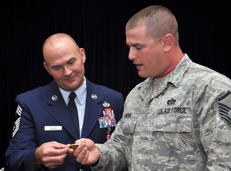 Master Sgt. Bradley Brown, 442nd Civil Engineer Squadron noncommissioned officer in charge of heavy equipment (right), presents Chief Master Sgt. Cody Ellett, 442 Civil Engineer manager, with a coin at Elletts retirement ceremony, Dec. 1. Ellett retired after many years of service to the Air Force. The 442nd CES is part of the 442nd Fighter Wing, an A-10 Thunderbolt II Air Force Reserve unit at Whiteman Air Force Base, Mo. (U.S. Air Force photo by Senior Airman Wesley Wright/Released)