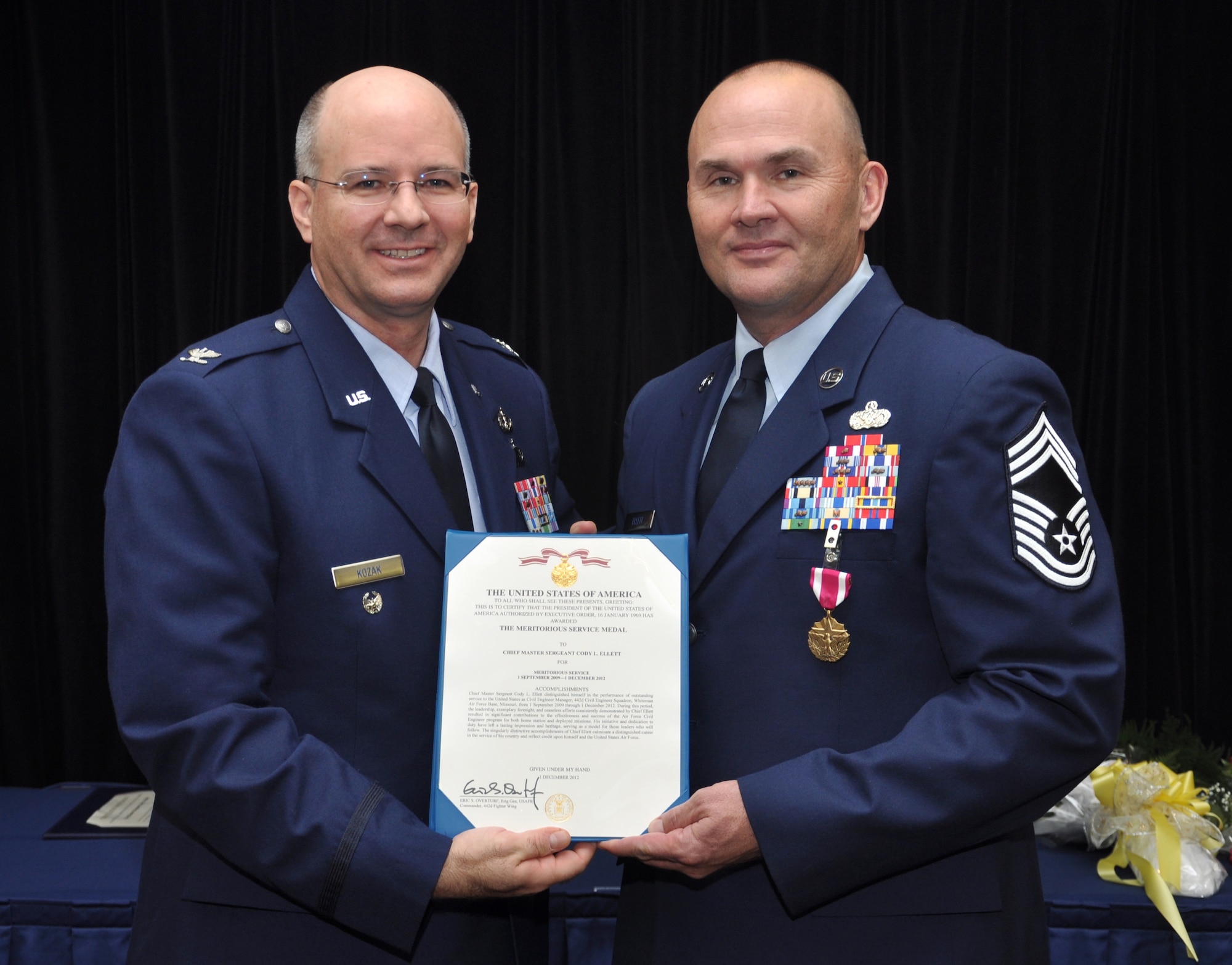 Col.Michael Kozak, deputy director of readiness and emergency managment, Headquarters, Air Force, (left) presents Chief Master Sgt. Cody Ellett, 442 Civil Engineer manager, with the Meritorious Service Medal at Elletts retirement ceremony, Dec. 1. Ellett retired after many years of service to the Air Force. The 442nd CES is part of the 442nd Fighter Wing, an A-10 Thunderbolt II Air Force Reserve unit at Whiteman Air Force Base, Mo. (U.S. Air Force photo by Senior Airman Wesley Wright/Released)