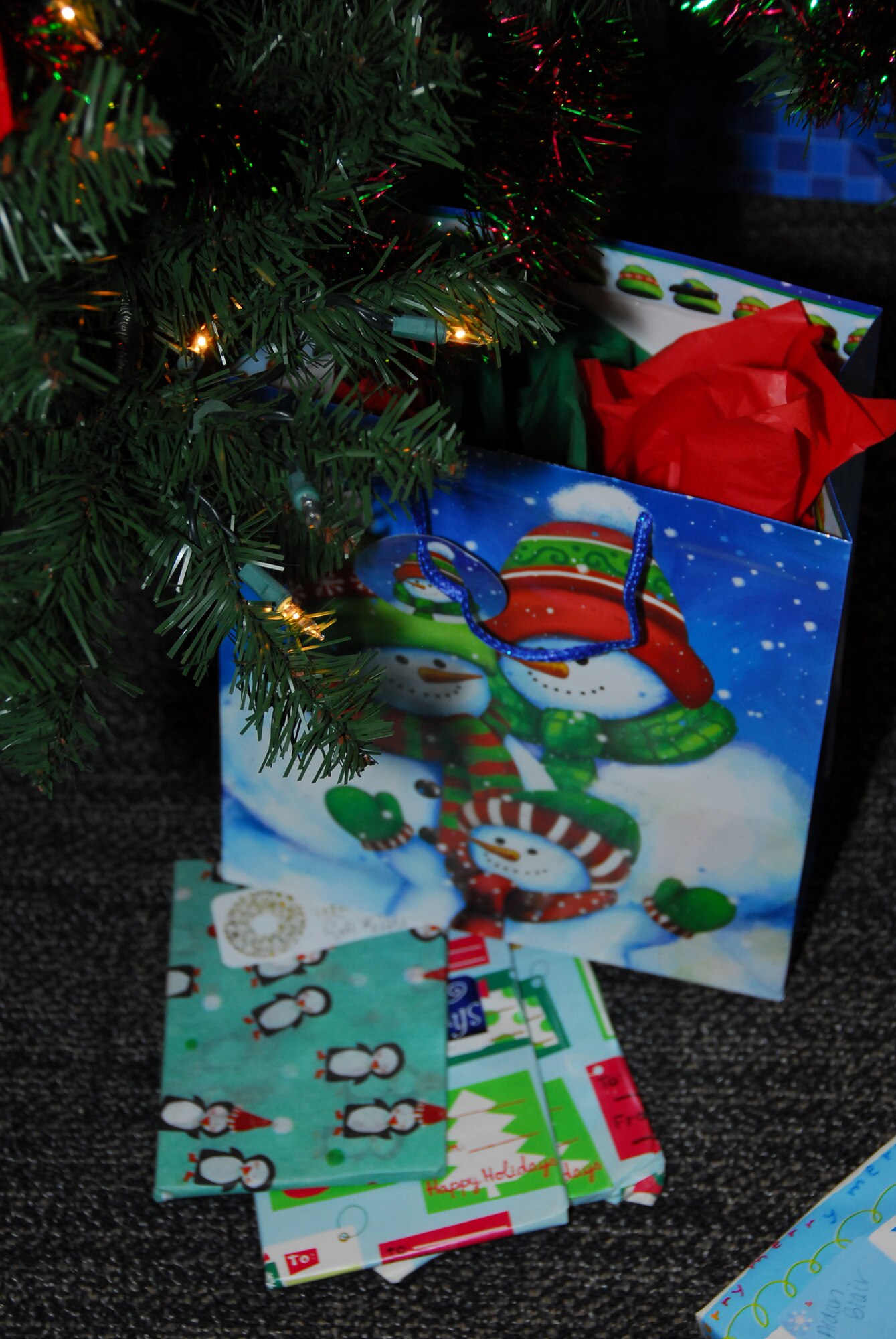Gifts sit under the Christmas waiting to be given out by Santa Claus.  Santa Claus arrived via a 53rd Weather Reconnaissance Squadron WC-130J to hand out gifts to children of the 403rd Wing servicemembers. (U.S. Air Force Photo by Tech. Sgt. Jessica L. Kendziorek)