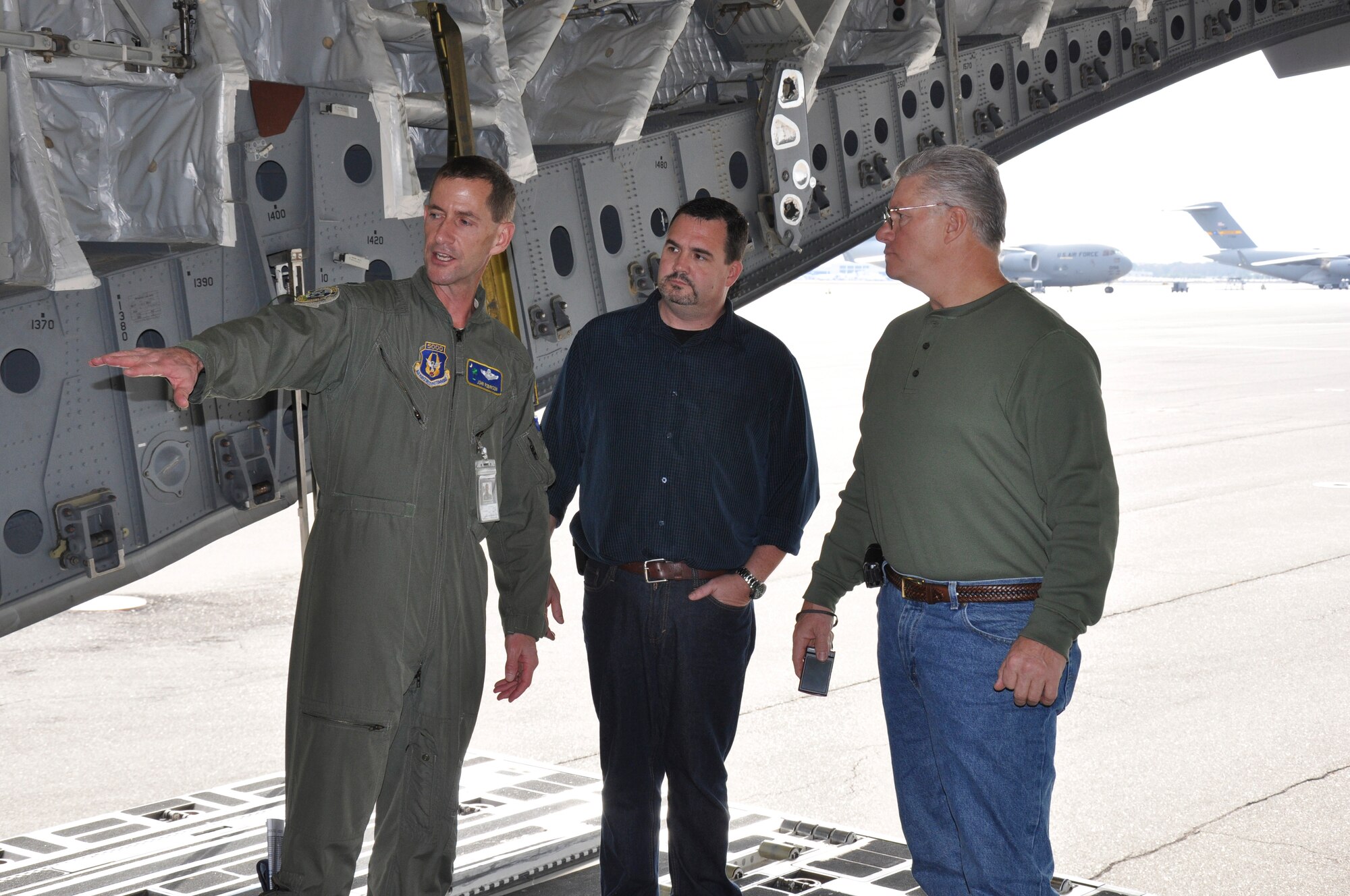 C-17 Globemaster III pilot Lt. Col. John Robinson explains cargo onload and offload proceedures to two community leaders Saturday Dec. 1, 2012, in the cargo bay of a C-17 at Joint Base Charleston, S.C. The civic leaders took part in the flight to become oriented with the mission of the Air Force Reserve. (U.S. Air Force photo by Senior Airman  Bobby Pilch)