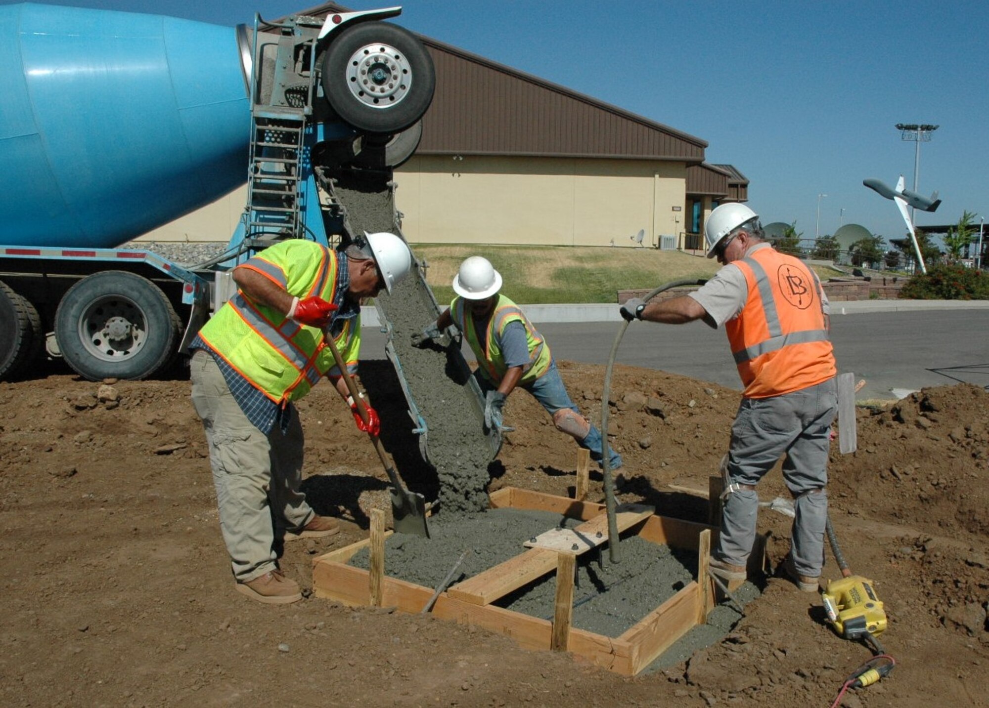 Workers pour a cement cornerpost for a pavilion being erected as part of the landscaping project for the newly constructed 13th Reconnaissance Squadron headquarters building. The facility is one of several Air Force Reserve Command funded projects completed at Beale Air Force Base, Calif. in Fiscal Year 2012. (U.S. Air Force photo by Dana Lineback)
