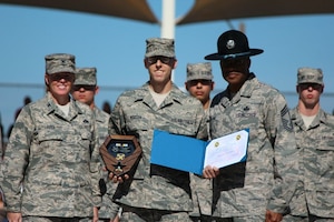 Colonel Deborah Liddick, Commander 737th Training Group, and Chief Master Sergeant Kenneth Williams, Superintendent 737th Training Group recognize Airman Andrew Morgan from the 321st Training Squadron, Flight 693 as the Top Graduate from the Basic Military Training graduating on Nov. 9, 2012. Morgan will be assigned to the 477th Aircraft Maintenance Squadron as an F-22 avionics specialist. (Courtesy Photo)