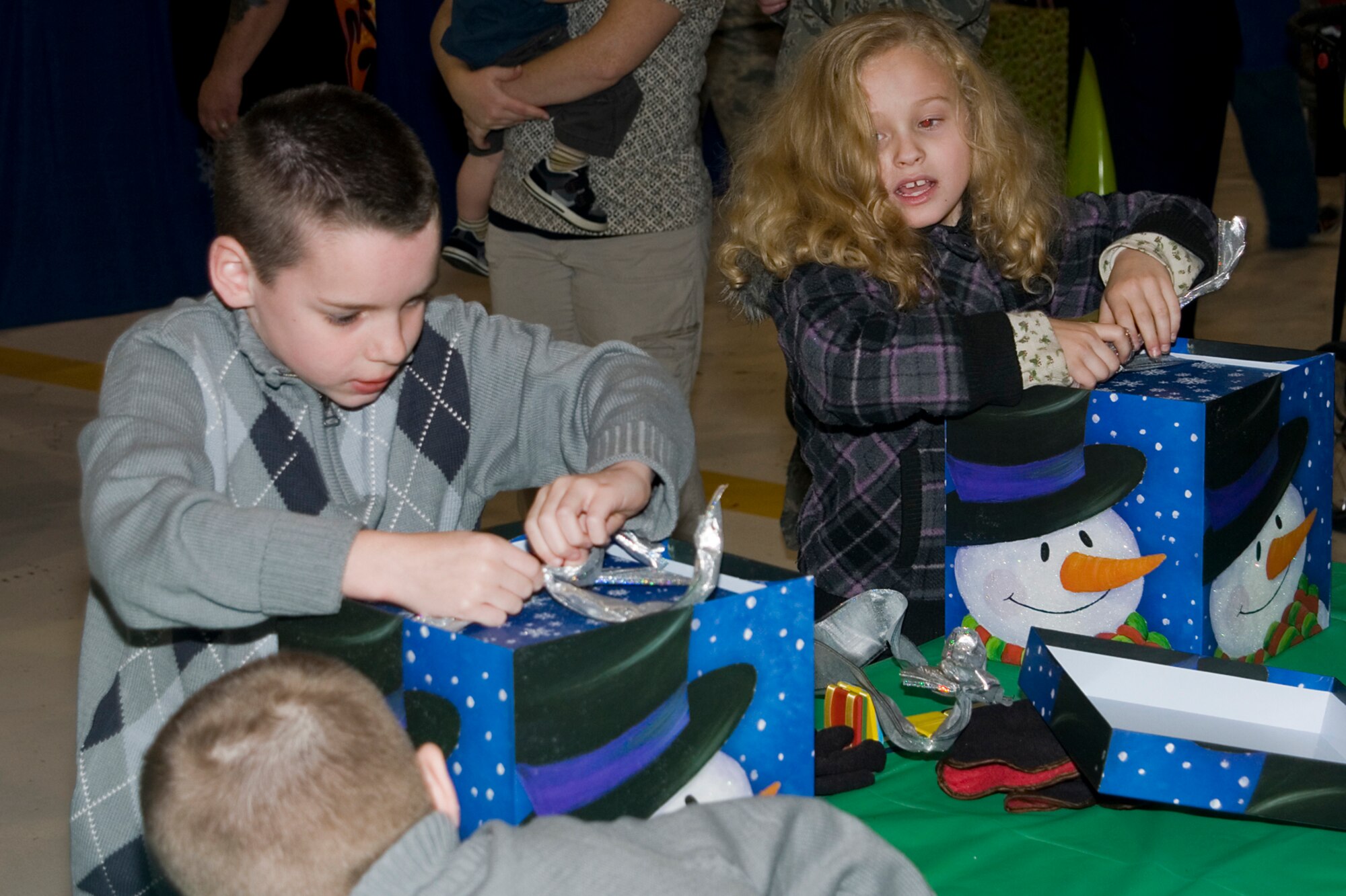 GRISSOM AIR RESERVE BASE, Ind. -- Jake Buckley, son of Col. Don Buckley, 434th Air Refueling Wing commander, hurries to open a box to win a prize during a contest at the wing Christmas party here Dec. 1. The party included a variety of activities and games for unit members and their families in celebration of the holiday season. (U.S. Air Force photo/Senior Airman Andrew McLaughlin)