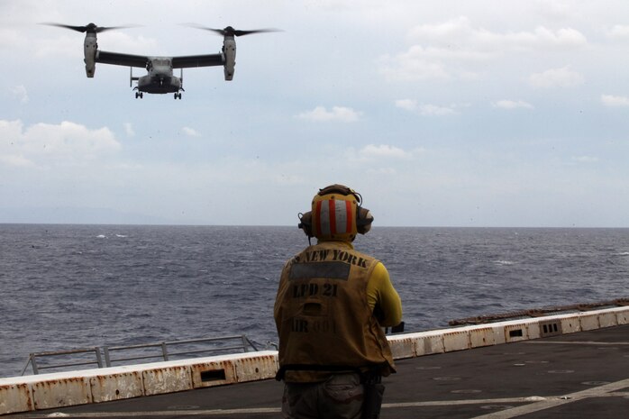 A Sailor with the Iwo Jima Amphibious Ready Group watches an MV-22 Osprey prepare to land on the flight deck of the USS New York, Nov. 29, 2012. The 24th Marine Expeditionary Unit is deployed with the Iwo Jima Amphibious Ready Group in the 6th Fleet area of responsibility serving as an expeditionary crisis response force capable of a variety of missions from full-scale combat to evacuations and humanitarian assistance.